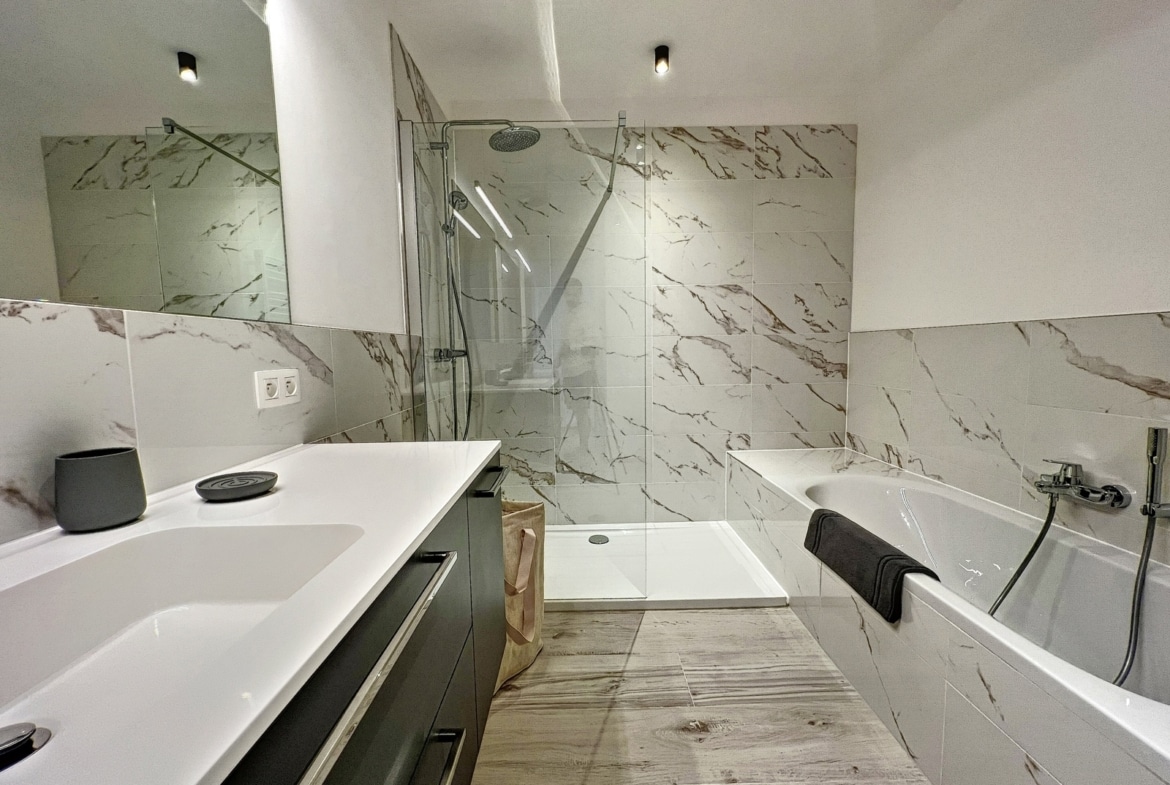 Moderne badkamer met inloopdouche en ligbad in het appartement.