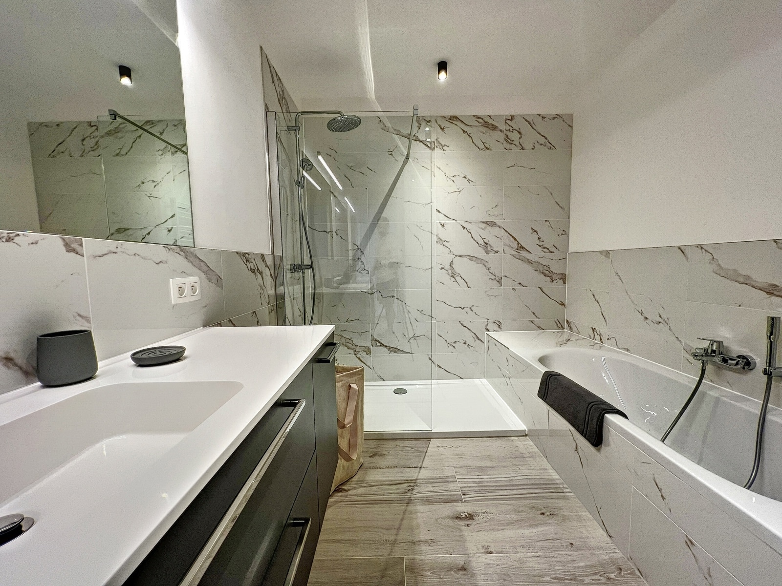 Moderne badkamer met douche – You Real Estate Agency Moderne badkamer met inloopdouche en ligbad in het appartement.