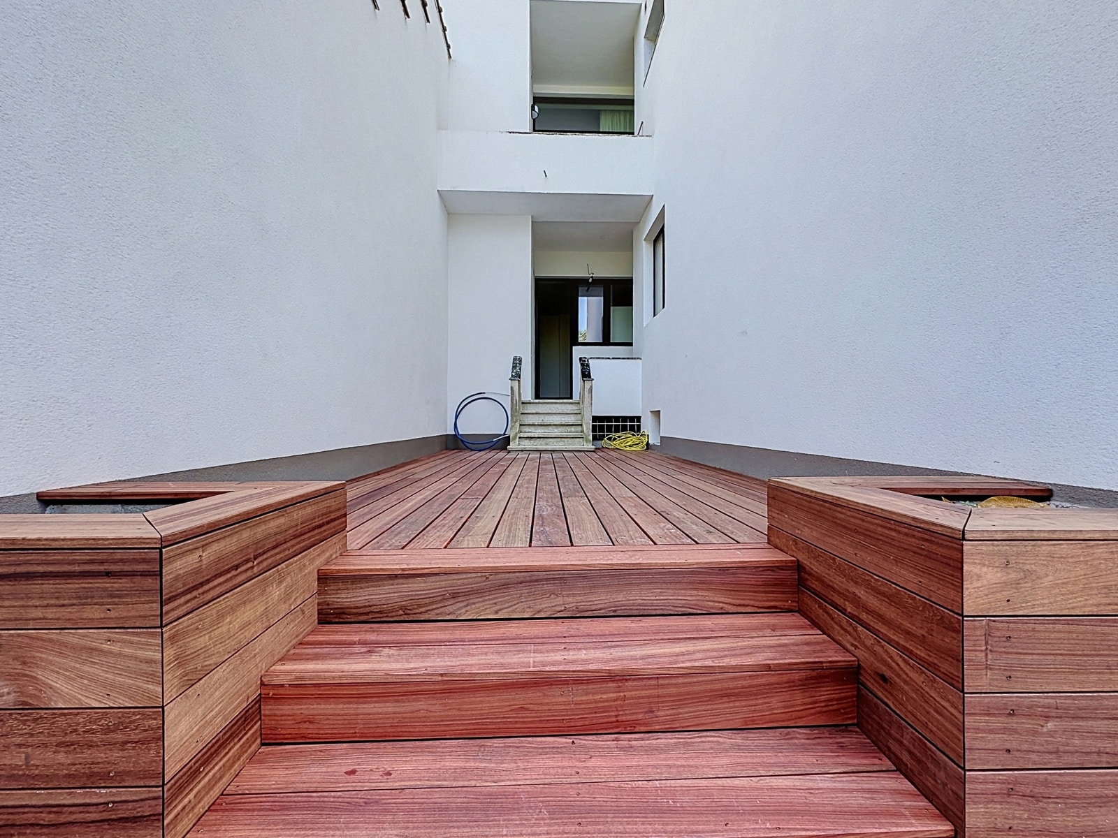 Terrasse en Bois dans Cour Intérieure – You Real Estate Agency Terrasse en bois moderne dans cour intérieure lumineuse d’une maison contemporaine.