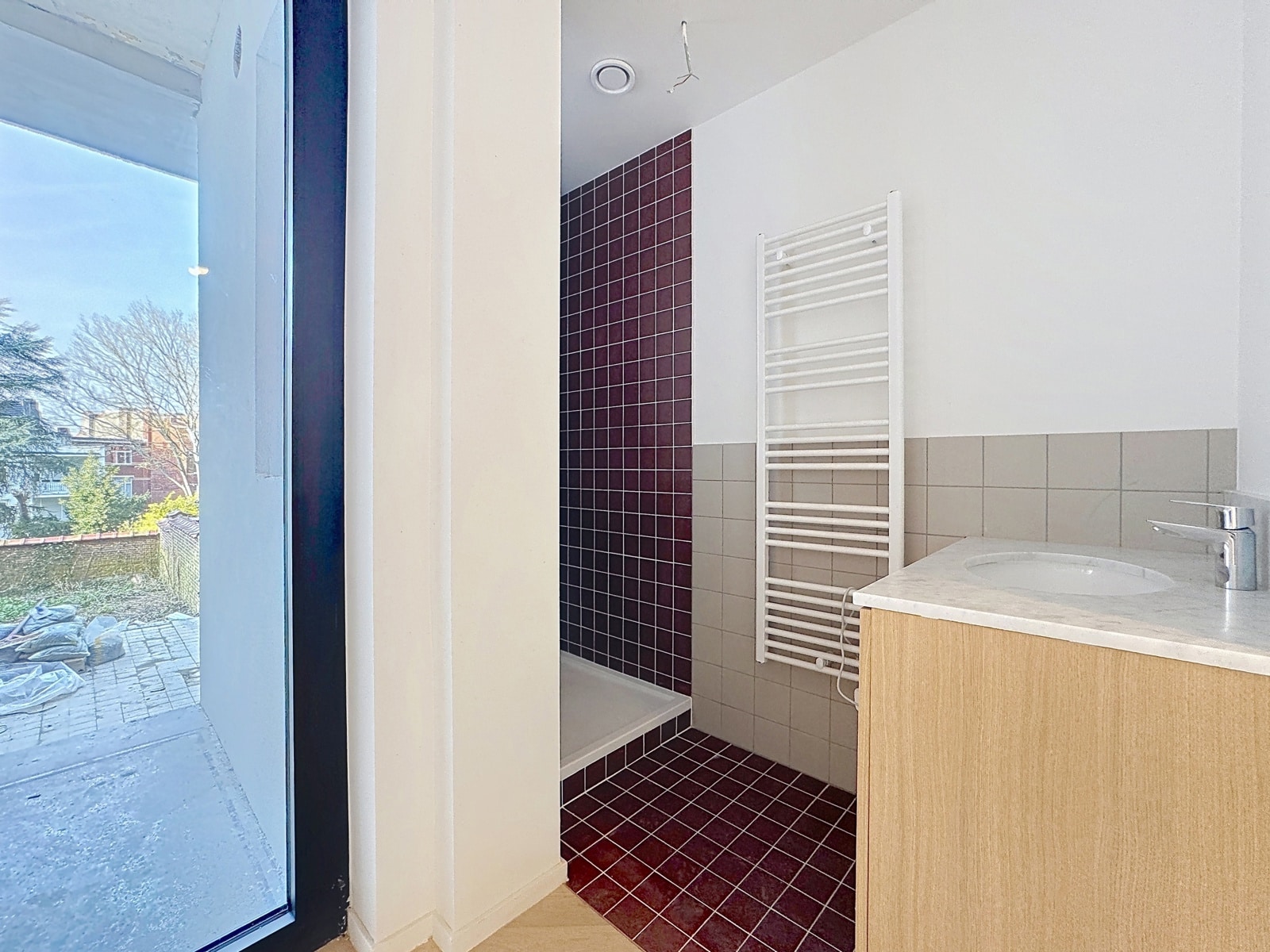 Salle de Bain Lumineuse avec Terrasse – You Real Estate Agency Salle de bain moderne lumineuse avec douche et accès à la terrasse.