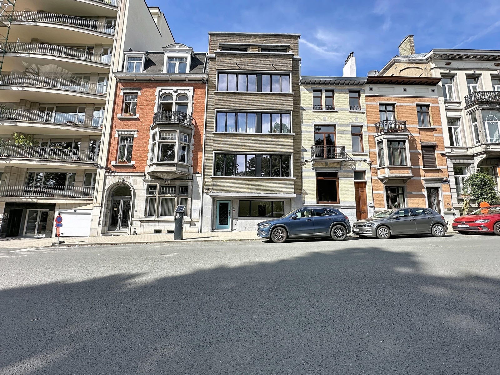 Façades Résidentielles Ensoleillées – You Real Estate Agency Façades d’appartements et maisons de ville sur rue résidentielle ensoleillée.
