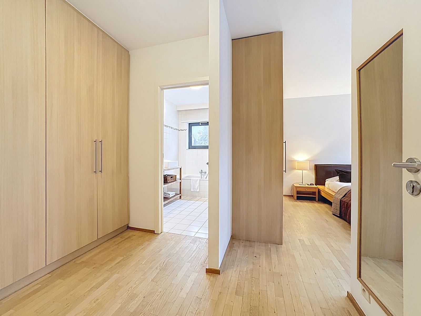 Dressing Entre Chambre Et Salle De Bain – You Real Estate Agency Dressing moderne reliant chambre et salle de bain dans un appartement lumineux.