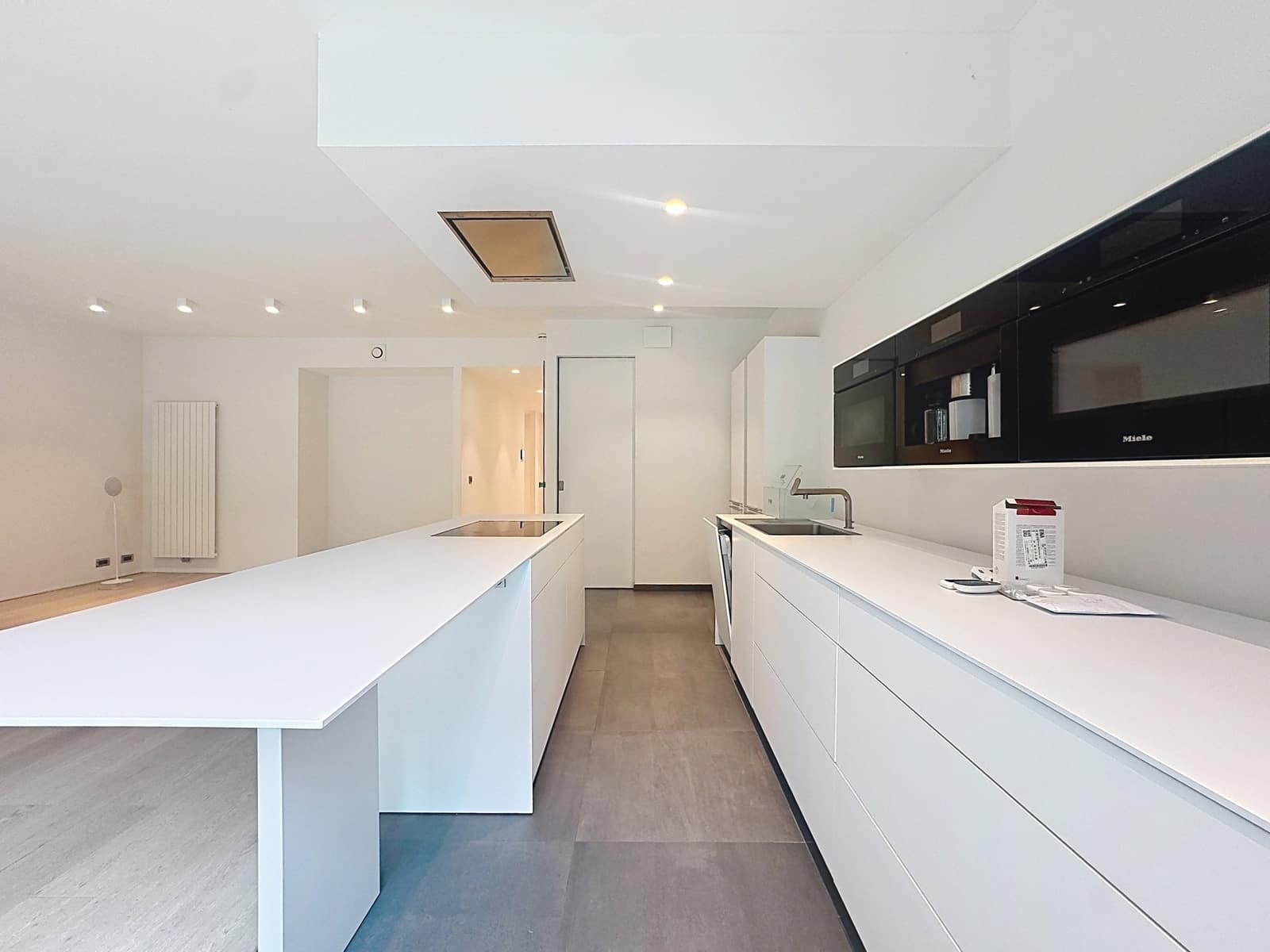 Open Kitchen with Central Island – You Real Estate Agency Modern open kitchen with a white central island in a contemporary apartment.