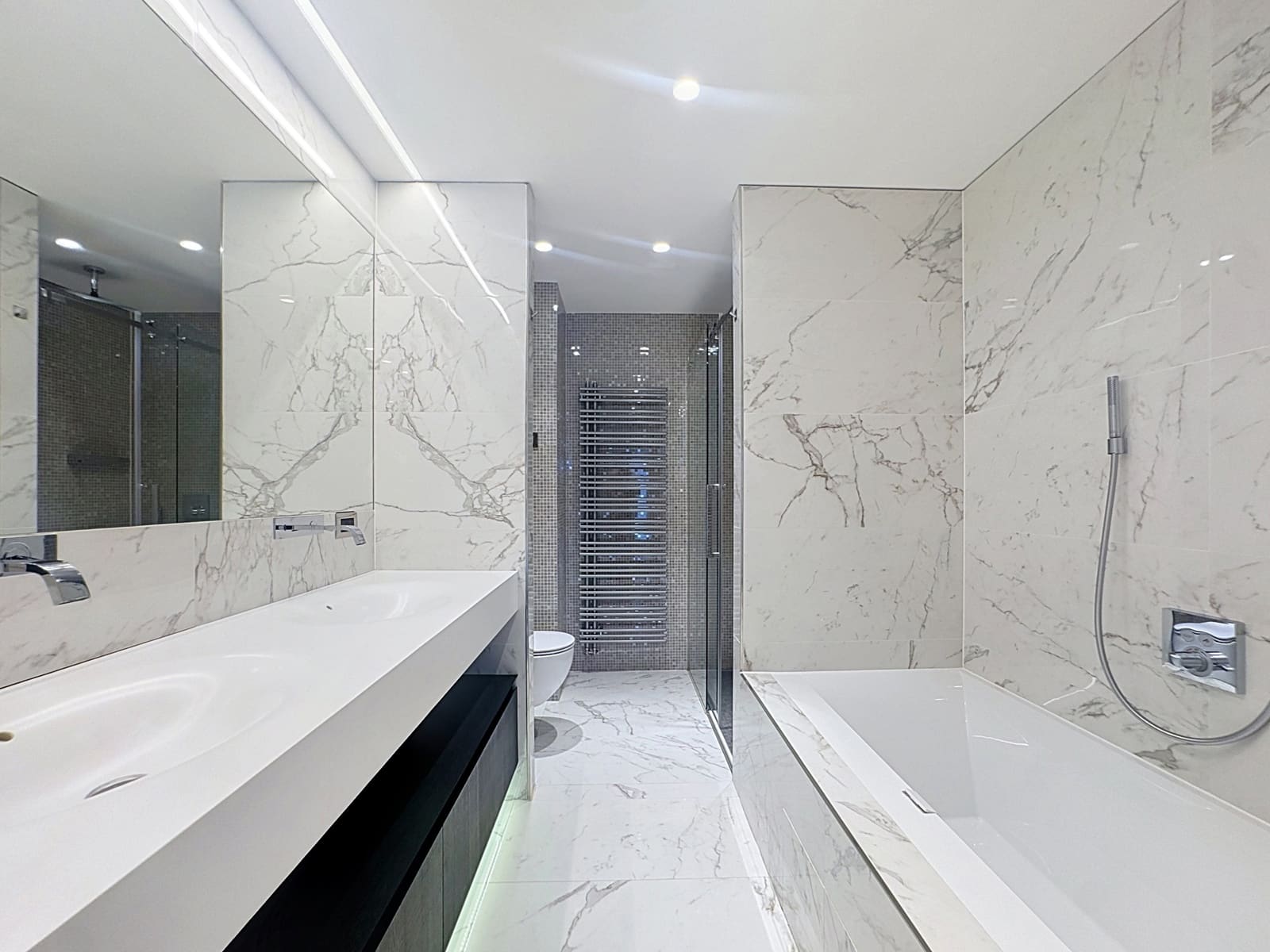 Marble Bathroom with Double Sink – You Real Estate Agency Modern marble bathroom with a double sink and a freestanding bathtub.