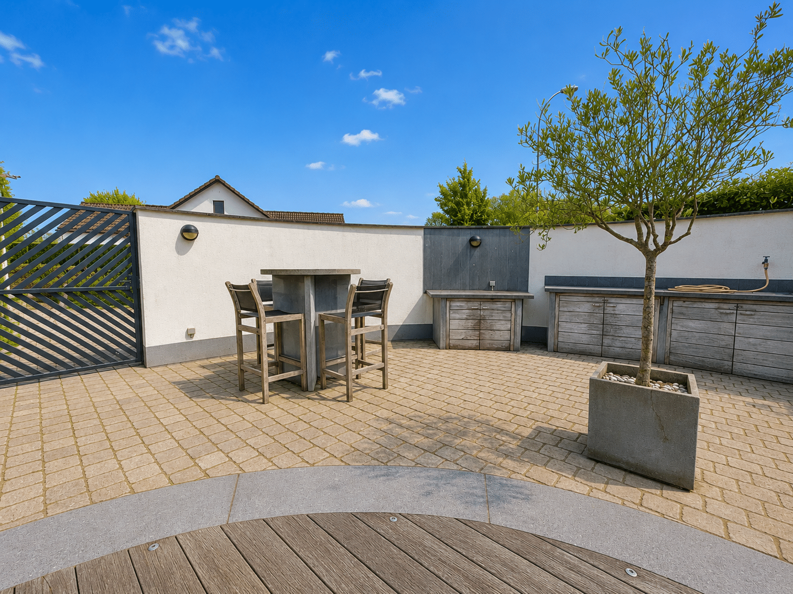 Patio with Outdoor Kitchen – You Real Estate Agency A house terrace with an outdoor kitchen, high-end furniture, and a sunny patio.