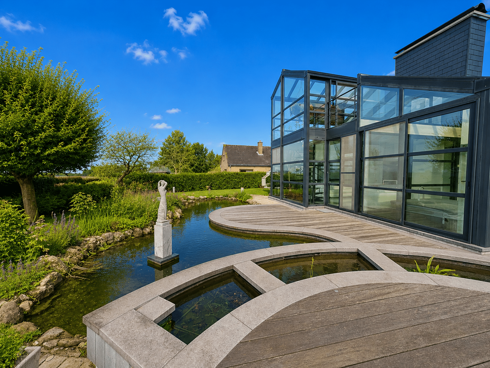 Modern House with a Landscaped Pond – You Real Estate Agency Contemporary home with a wooden deck, landscaped pond, and large picture windows.