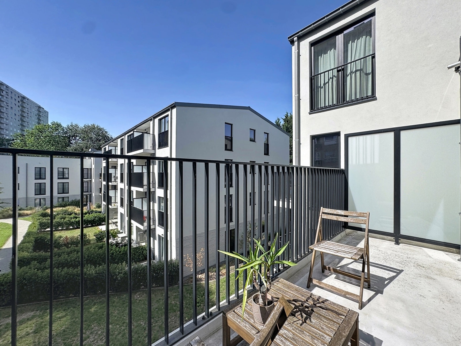 Terrasse Moderne avec Vue – You Real Estate Agency Terrasse d’appartement moderne avec mobilier bois et vue sur résidence neuve.