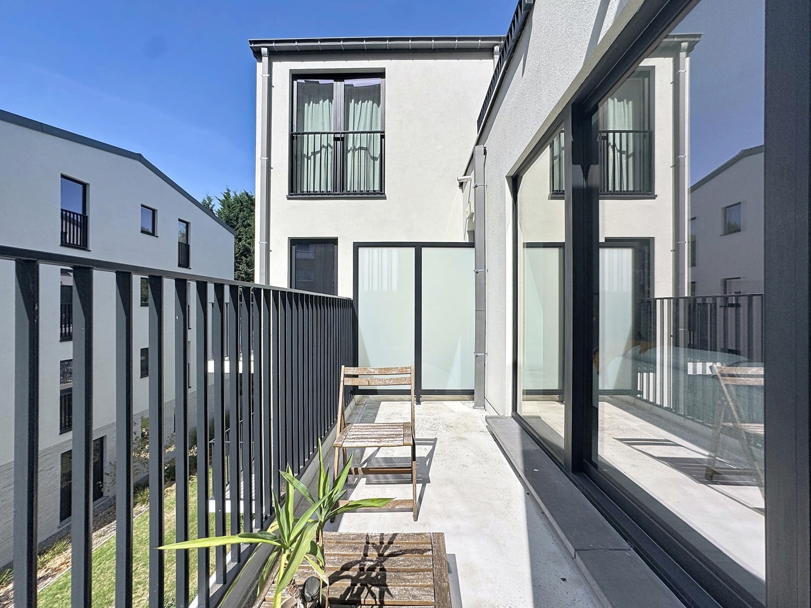 Balcon Terrasse Moderne Avec Vue – You Real Estate Agency Balcon terrasse moderne d’appartement avec mobilier bois et vue sur résidences contemporaines.