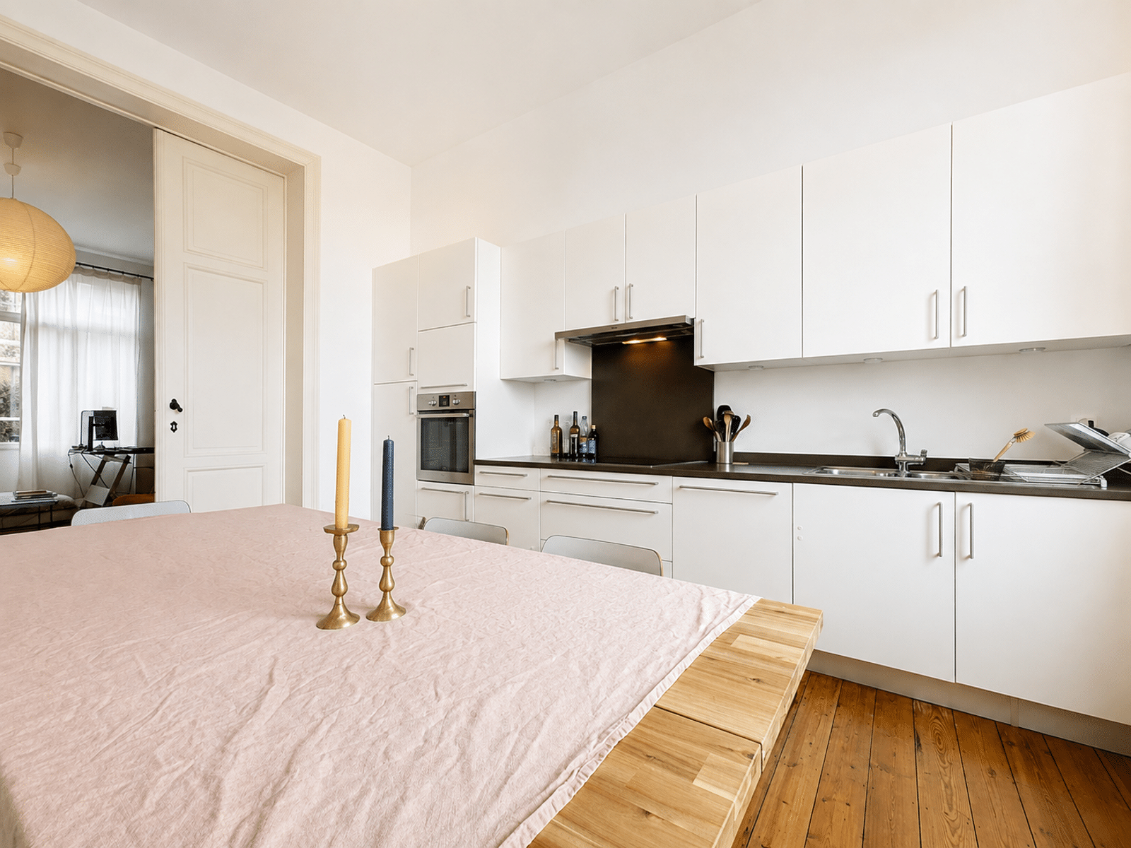 Cuisine Lumineuse avec Coin Repas – You Real Estate Agency Cuisine ouverte lumineuse d’appartement avec salle à manger moderne et parquet en bois.