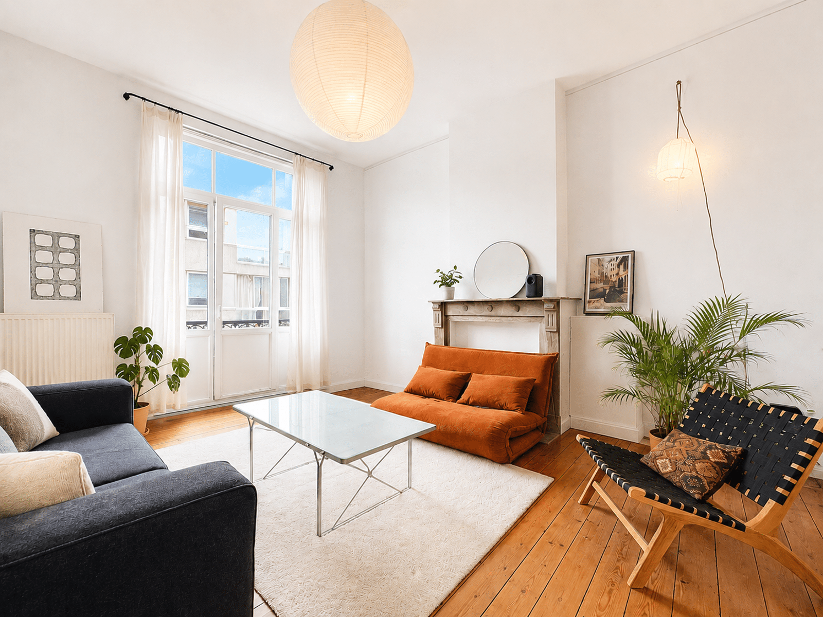 whise photo 3 Bright living room with white walls, orange sofa, glass coffee table, and sheer-curtained large window.