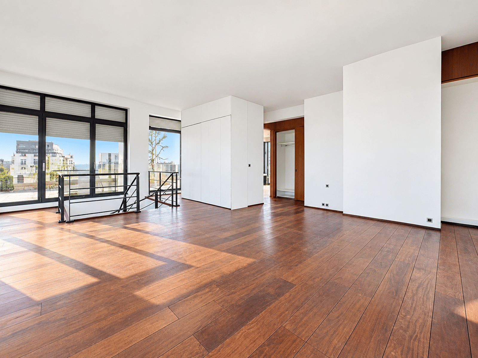 Salon Duplex Lumineux avec Terrasse – You Real Estate Agency Salon lumineux d’appartement duplex avec parquet, grandes baies vitrées et terrasse.