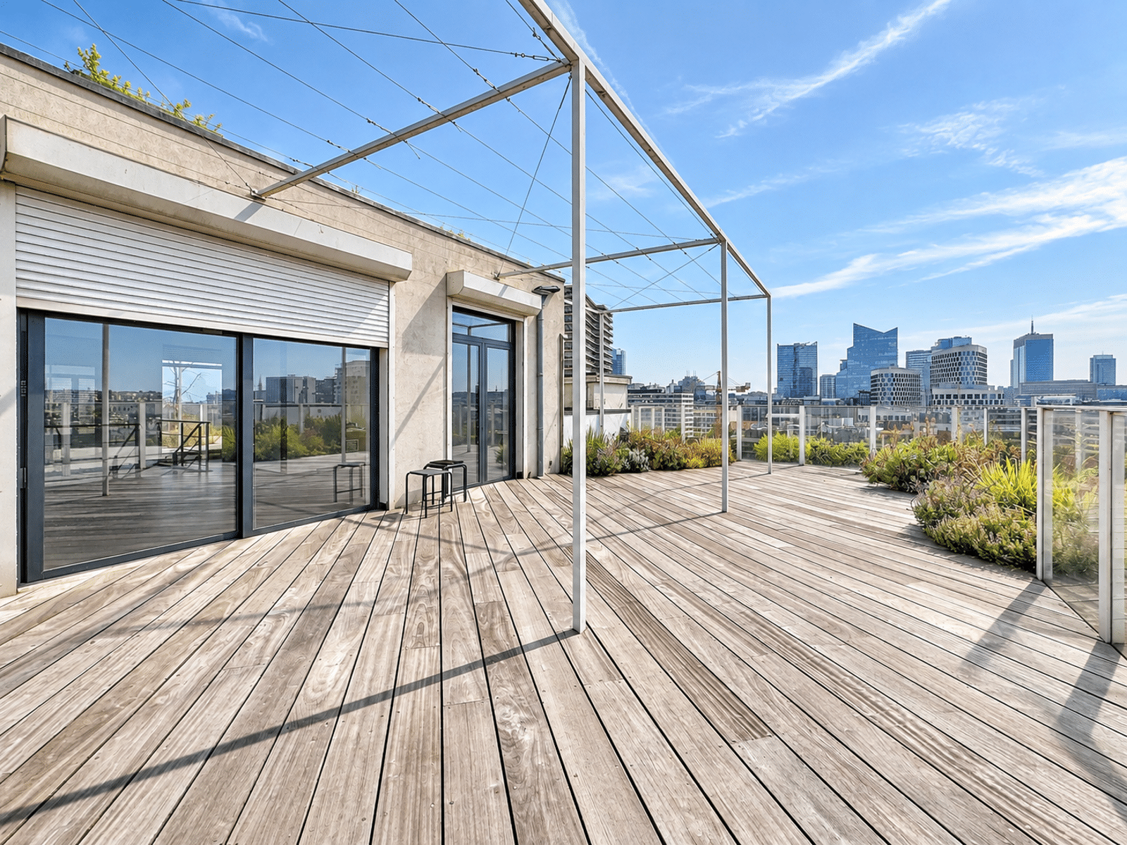 Terrasse Rooftop avec Vue Panoramique – You Real Estate Agency Terrasse rooftop d’appartement moderne avec vue panoramique sur la ville.