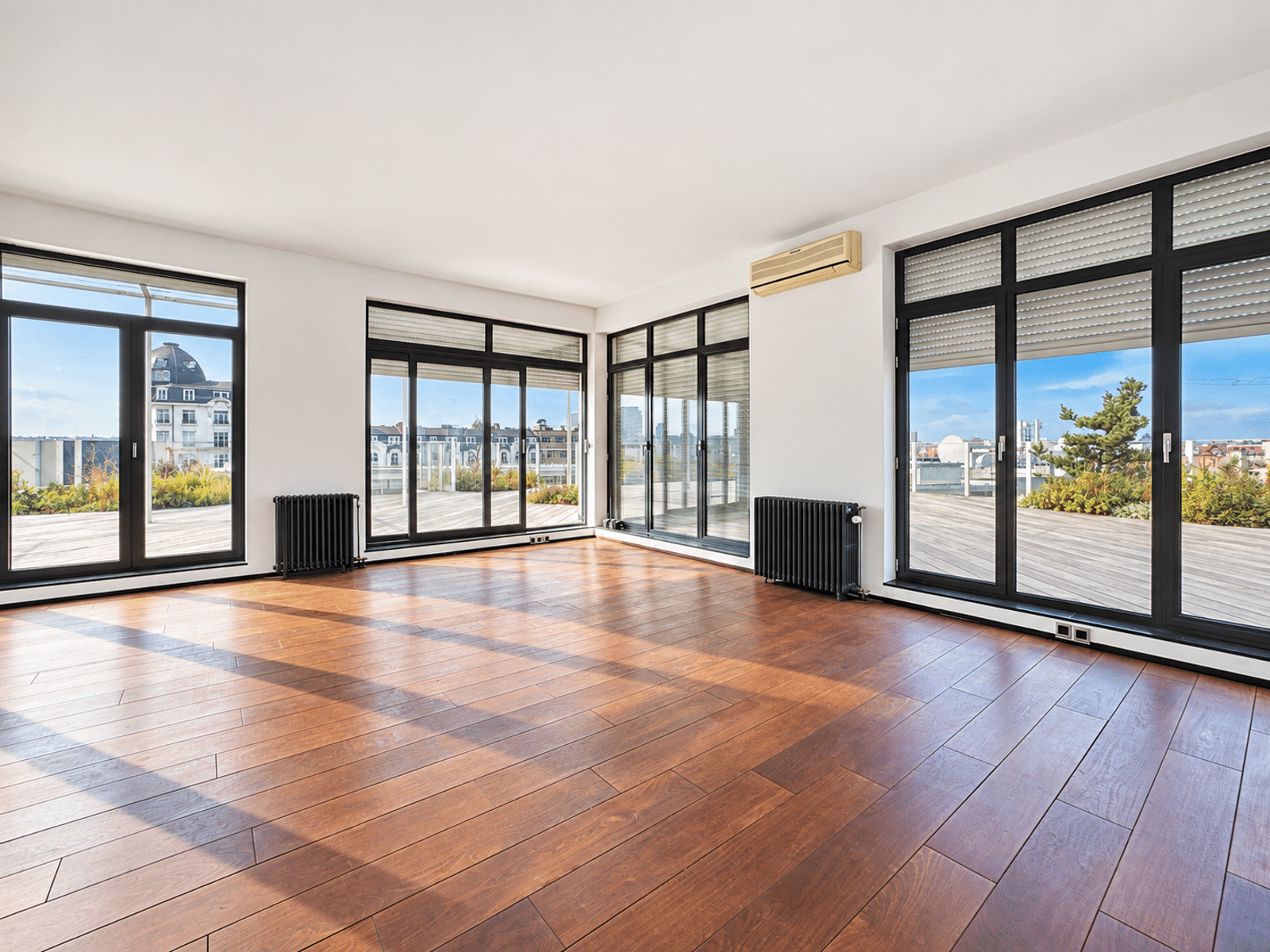 Séjour Lumineux avec Terrasse – You Real Estate Agency Salon lumineux d’appartement avec parquet, baies vitrées et terrasse panoramique.