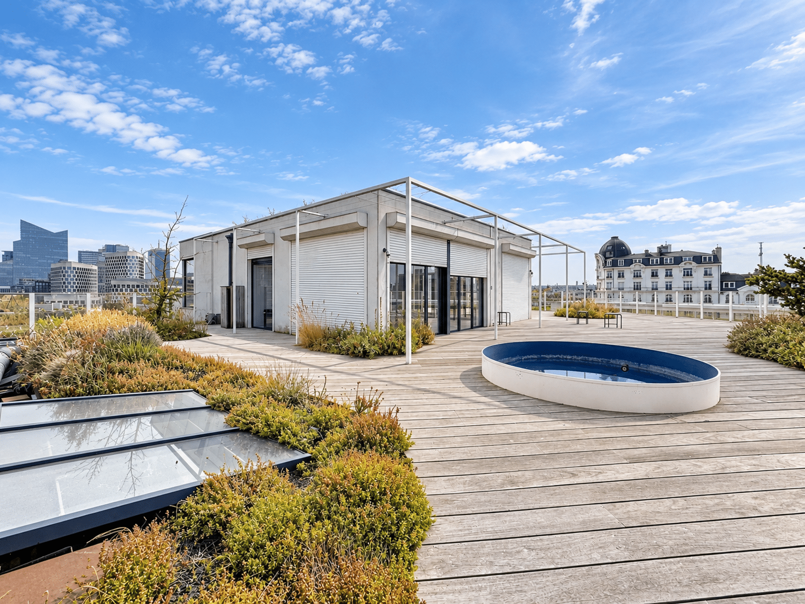 Toit-Terrasse avec Piscine – You Real Estate Agency Terrasse rooftop d’appartement avec piscine, sol en bois et vue urbaine panoramique.