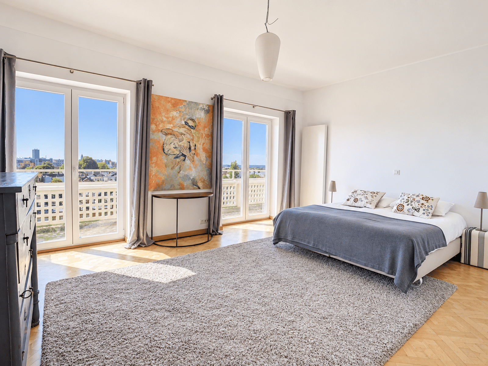 Chambre Lumineuse Avec Balcon – You Real Estate Agency Chambre lumineuse d’appartement avec balcon, parquet, lit moderne et grandes baies vitrées.