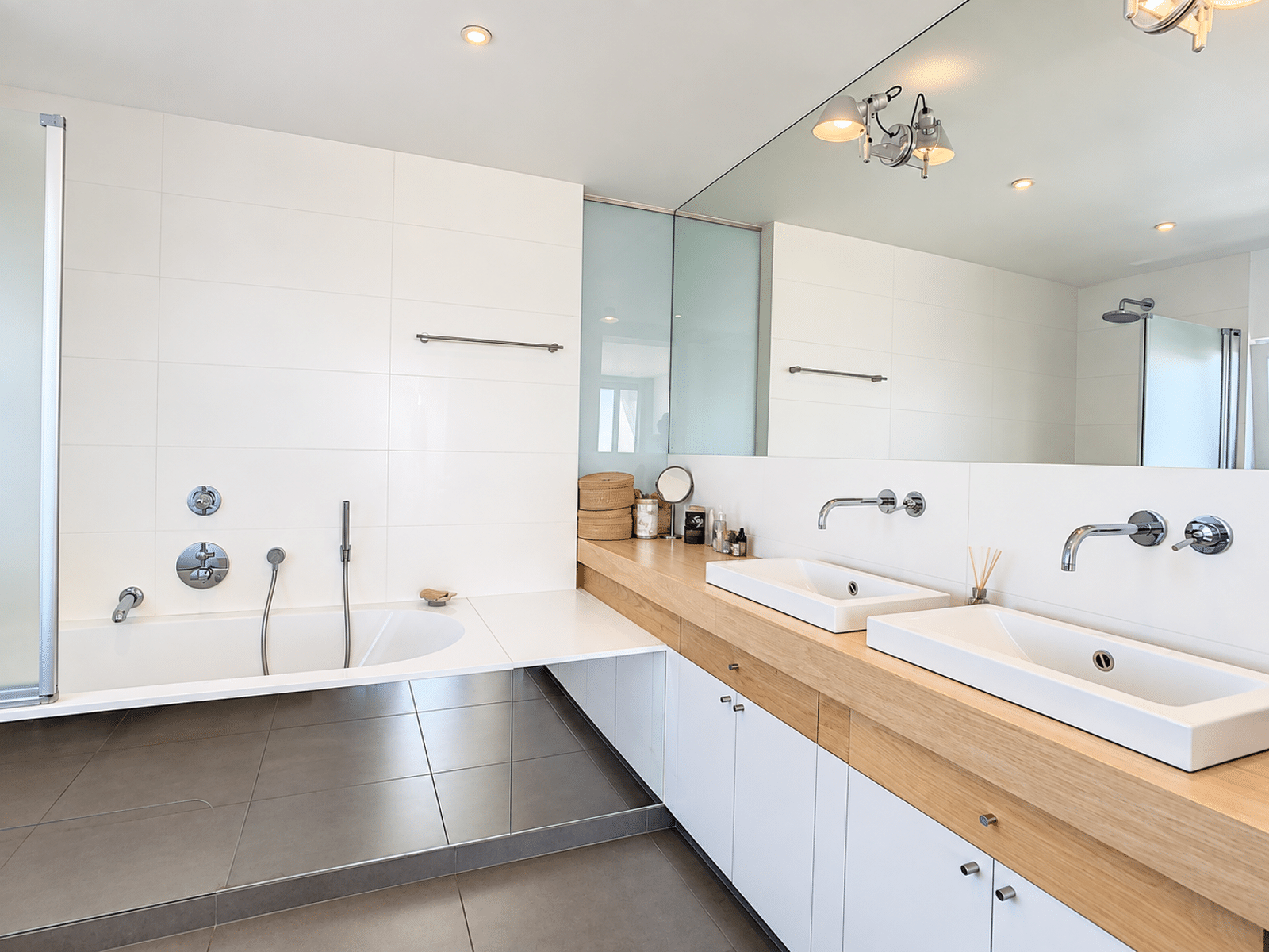Salle de Bain avec Double Vasque – You Real Estate Agency Salle de bain moderne avec double vasque et baignoire en appartement.