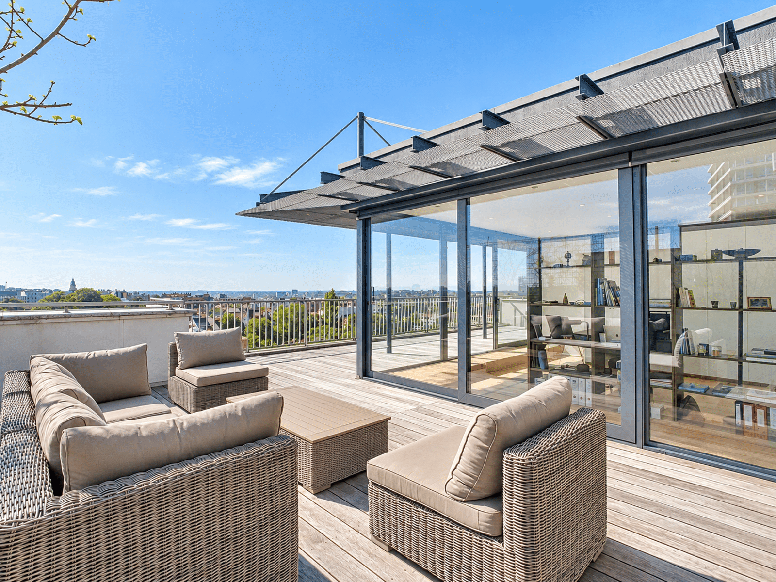 Terrasse Moderne avec Vue Urbaine – You Real Estate Agency Terrasse spacieuse d’appartement moderne avec salon extérieur et vue urbaine.