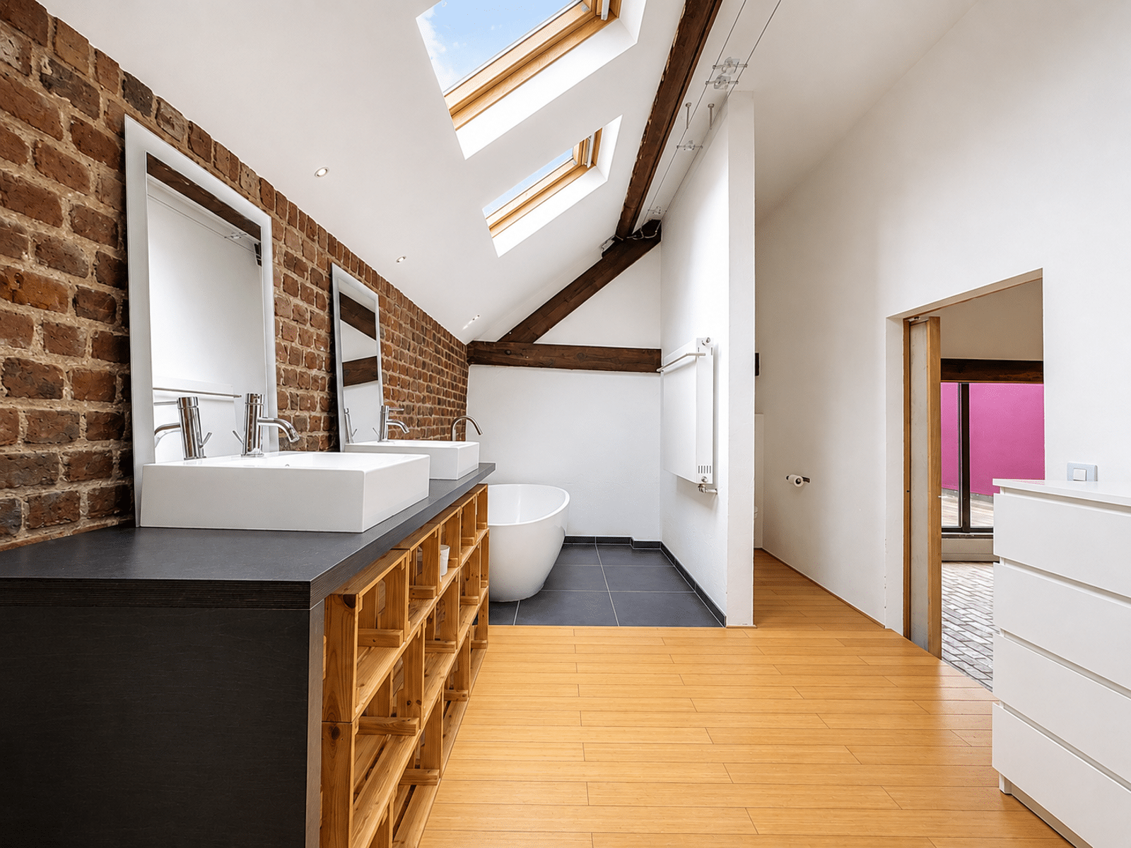 Salle de Bains Moderne Sous Combles – You Real Estate Agency Salle de bains moderne d’appartement sous combles avec baignoire et double vasque.