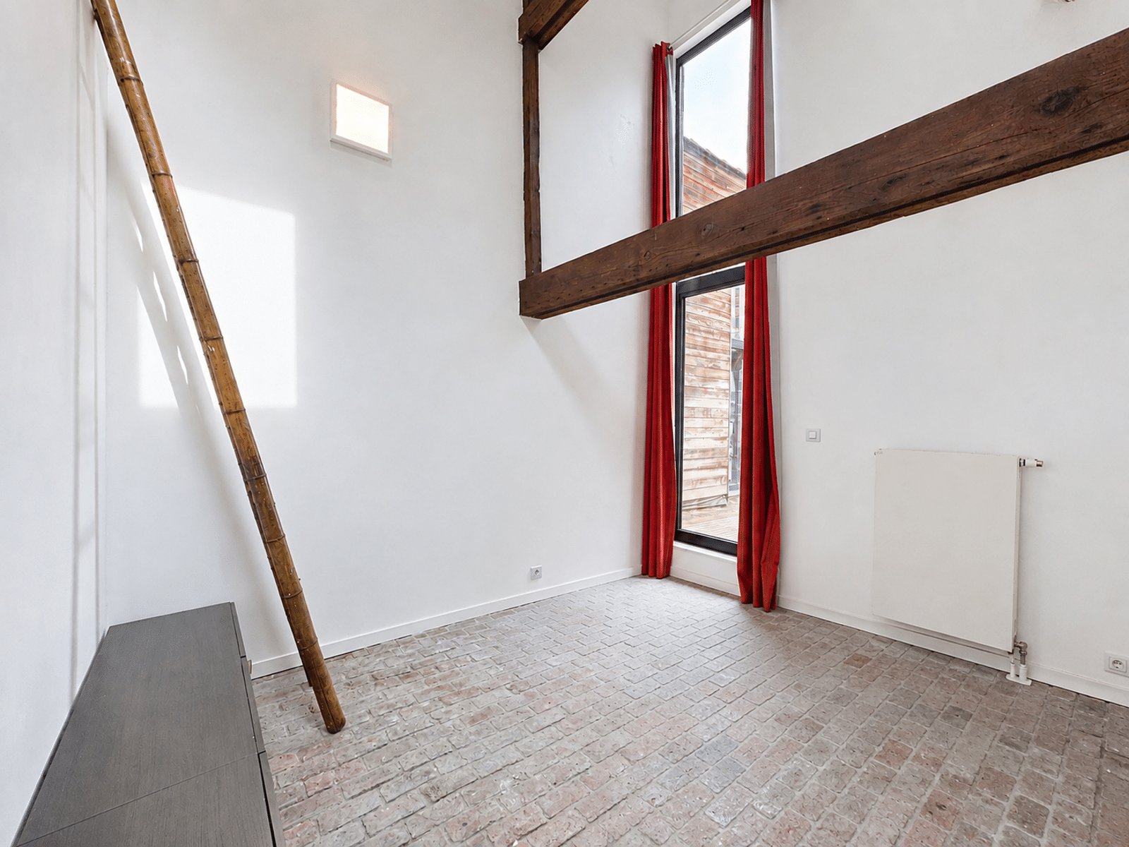 Pièce Lumineuse Avec Poutres – You Real Estate Agency Pièce lumineuse d’appartement avec poutres apparentes, échelle en bambou et grande fenêtre.