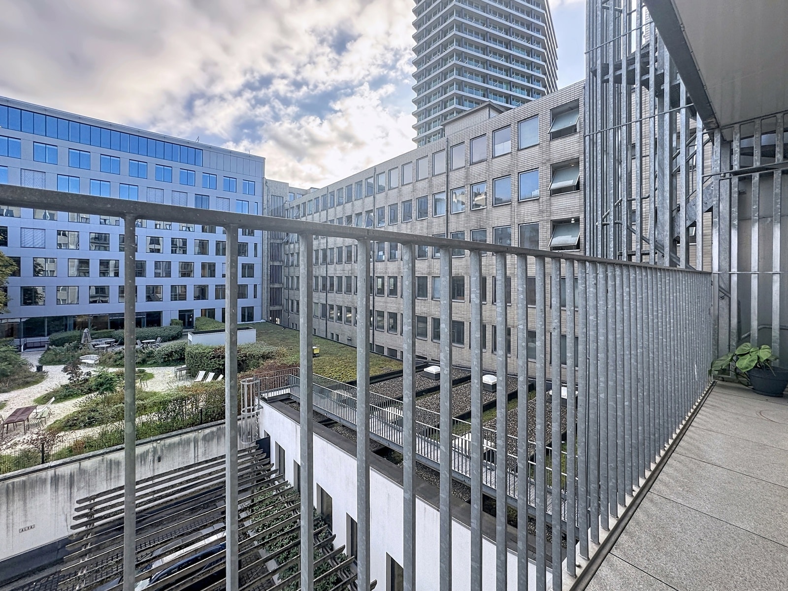 Vue Sur Cour Intérieure Moderne – You Real Estate Agency Vue depuis terrasse d’appartement sur cour intérieure moderne et immeubles résidentiels.