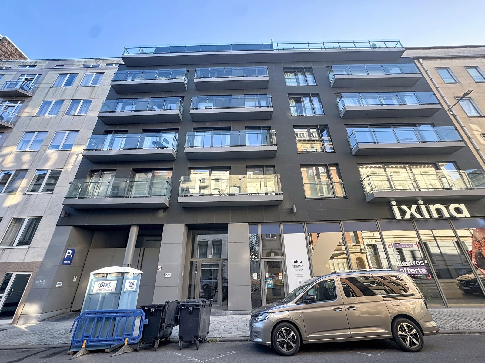 Façade Moderne Avec Balcons – You Real Estate Agency Immeuble moderne avec appartements et balcons, commerce en rez-de-chaussée.