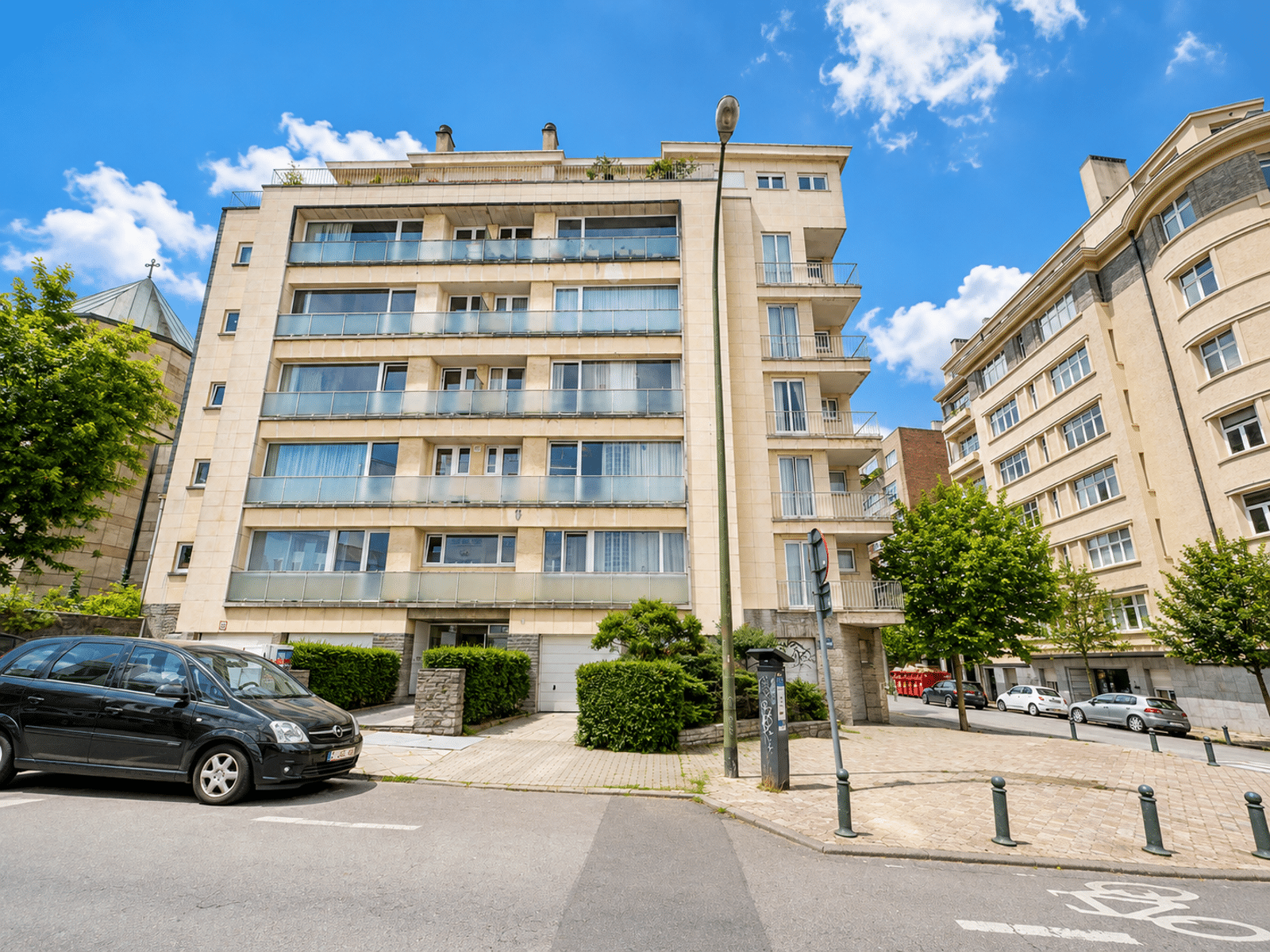 Façade D’Immeuble Moderne – You Real Estate Agency Immeuble d’appartements moderne avec balcons et terrasses en quartier résidentiel.