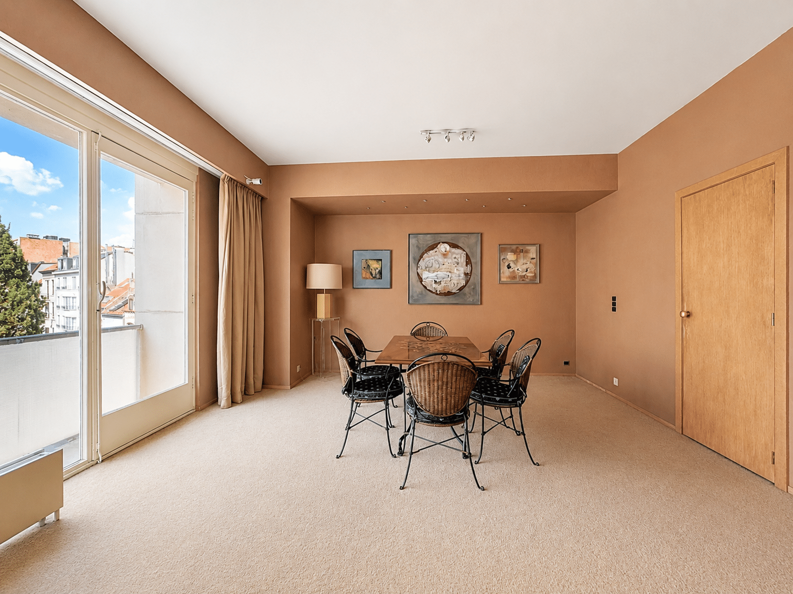 Lichte eetkamer met balkon – You Real Estate Agency Lichte eetkamer in een appartement met balkon en uitzicht op de stad.