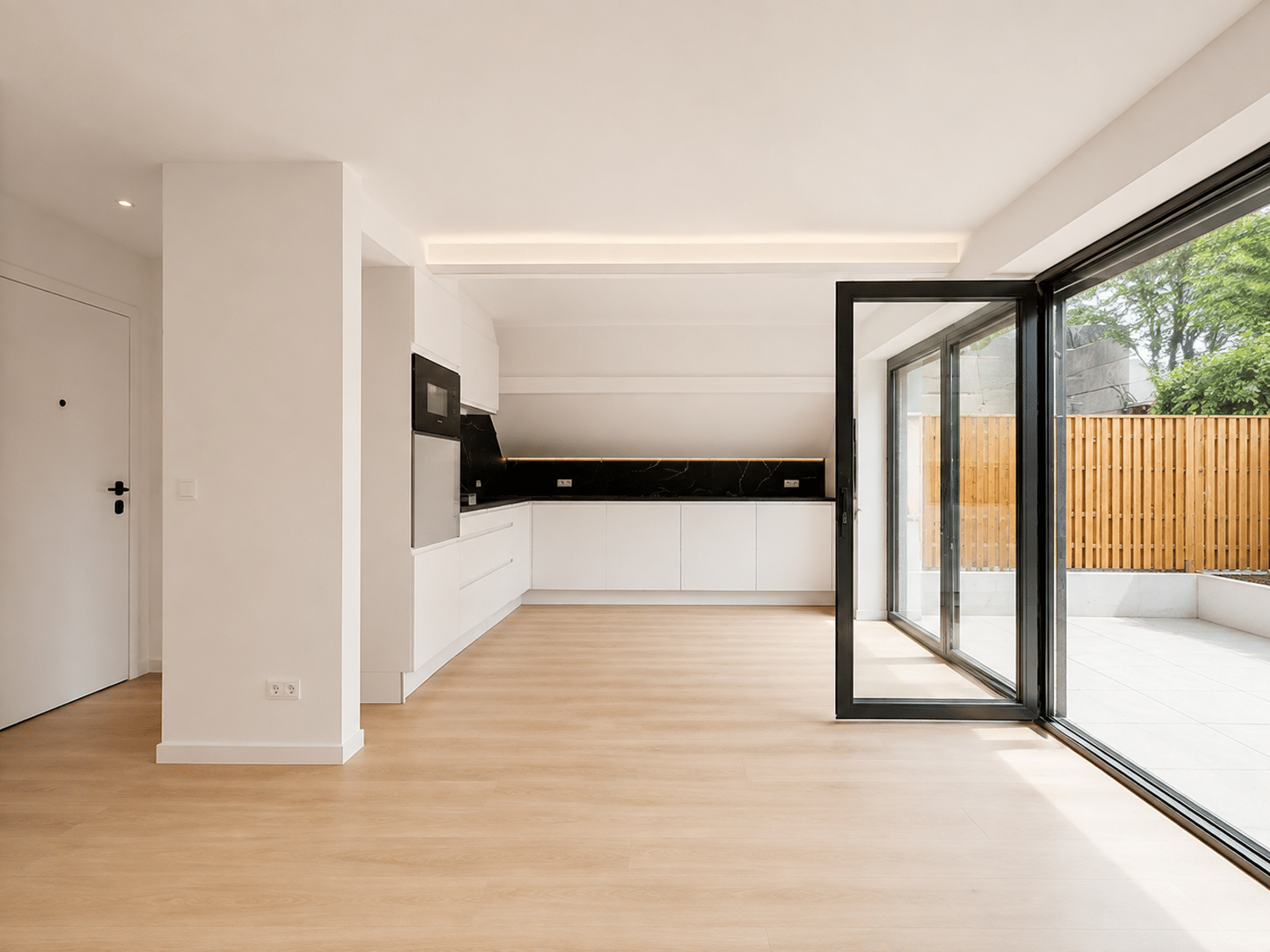 whise photo 4 Bright modern kitchen with white cabinets, black marble backsplash, and a large glass sliding door opening to a wooden-fenced outdoor patio.