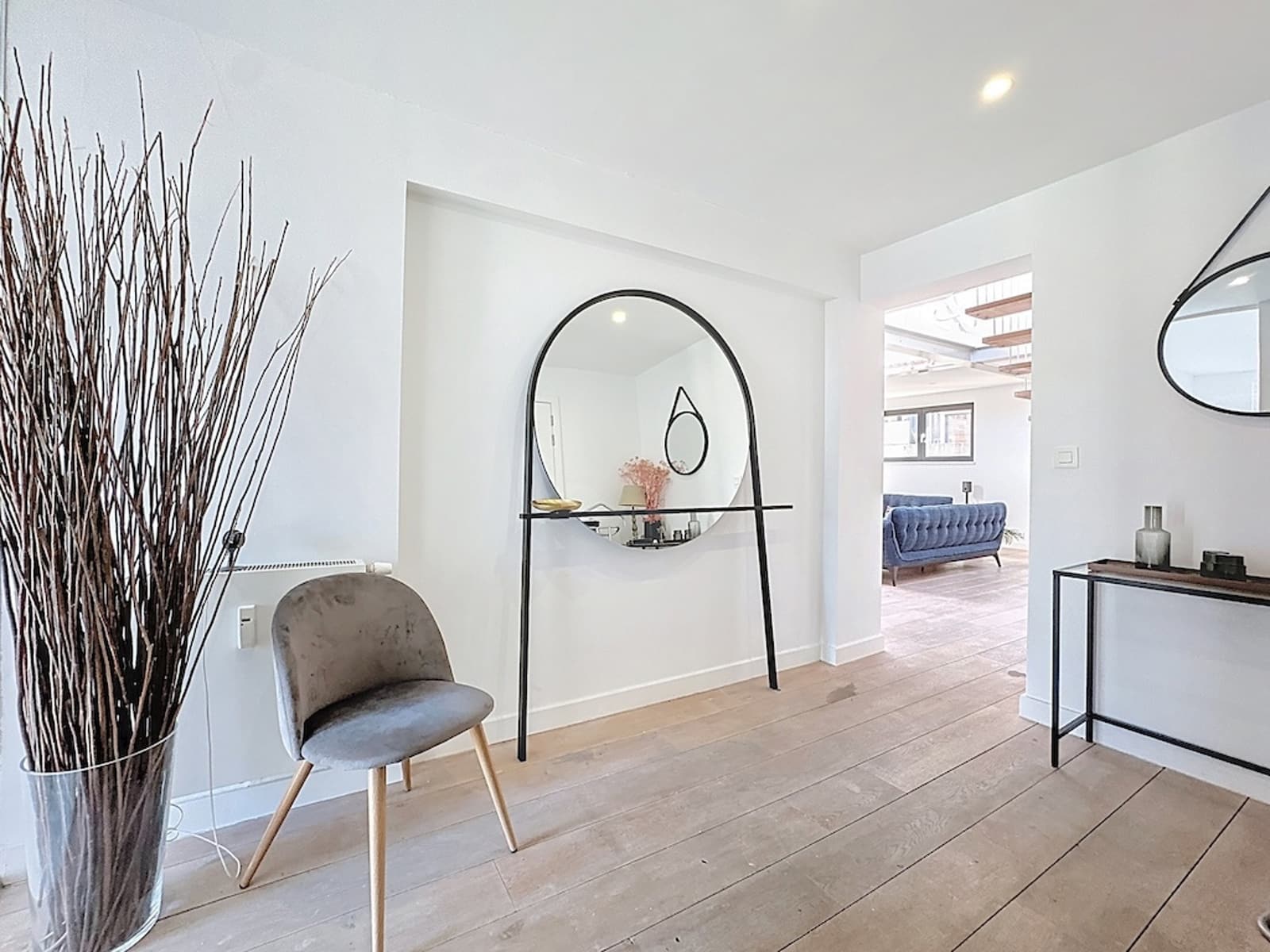 Entrée Moderne avec Grand Miroir – You Real Estate Agency Entrée moderne avec grand miroir, console design et parquet clair dans maison contemporaine.