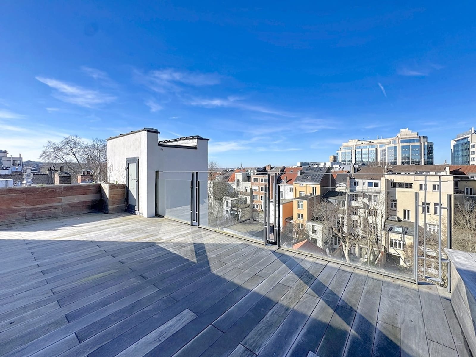 Toit-Terrasse Panoramique Ensoleillé – You Real Estate Agency Toit-terrasse d’appartement avec vue panoramique sur quartier urbain ensoleillé.