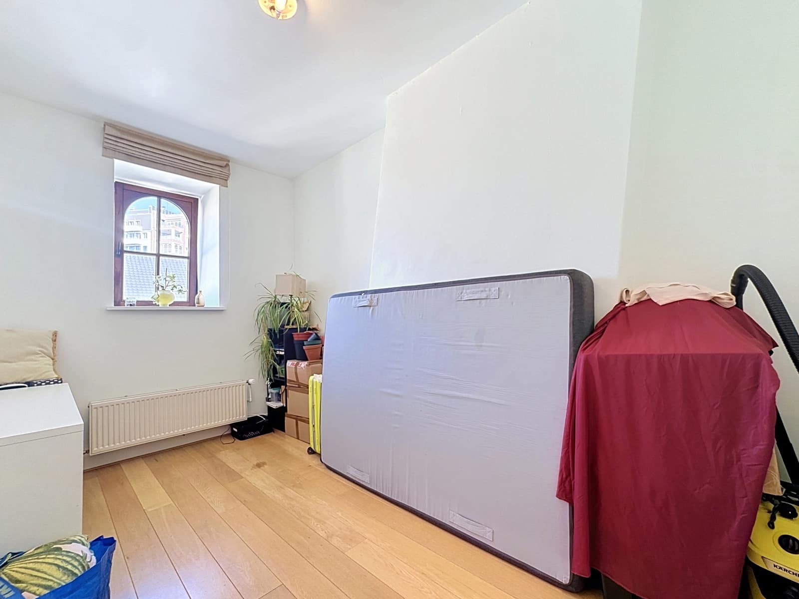 Pièce Lumineuse avec Fenêtre Cintrée – You Real Estate Agency Pièce lumineuse d’appartement avec parquet, fenêtre cintrée et rangements.