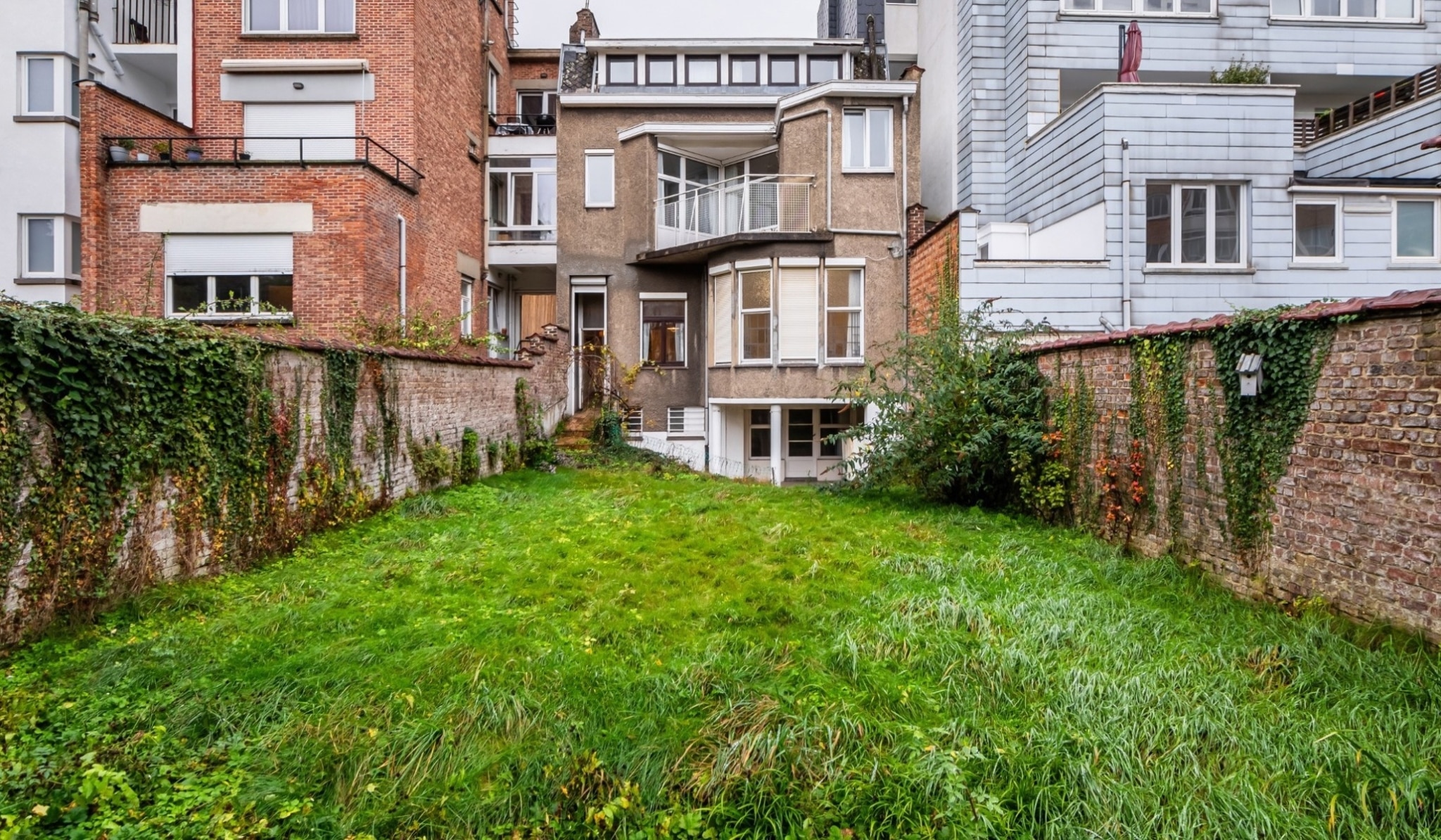 Private Urban Garden – You Real Estate Agency A private urban garden nestled between houses and apartments with a back terrace.