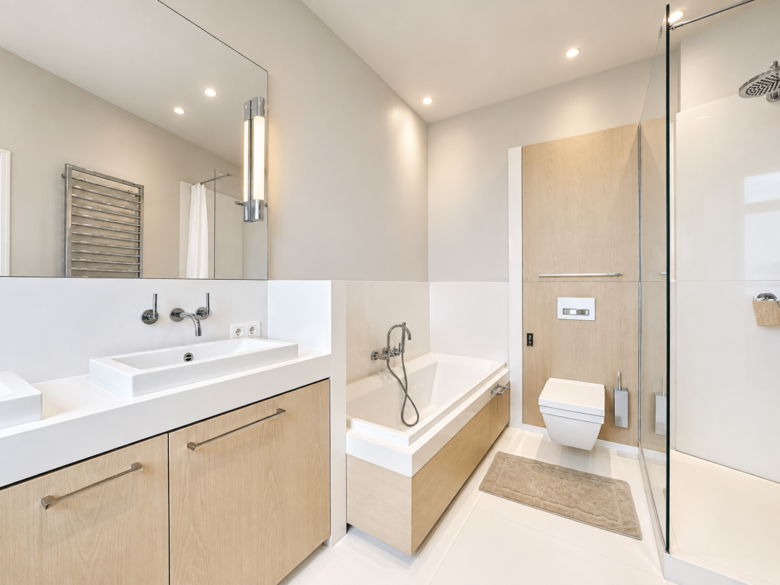 whise photo 7 Modern bathroom with a double vanity, rectangular sink, wall faucets, large mirror, and light wood cabinets.