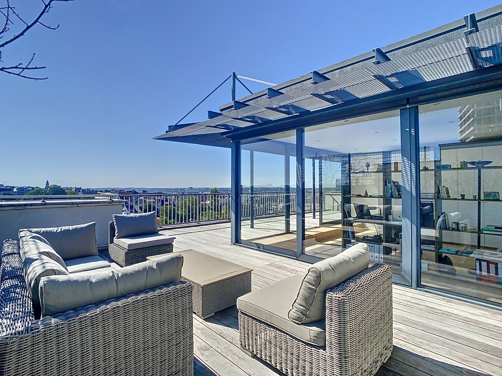 Terrasse Rooftop avec Vue Urbaine – You Real Estate Agency Terrasse rooftop moderne avec salon extérieur et vue urbaine.