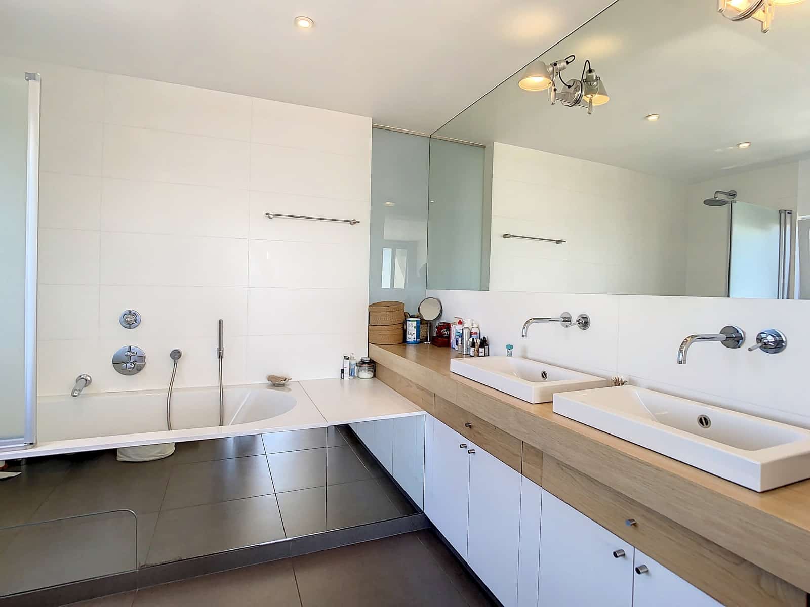 Salle de Bains avec Double Vasque – You Real Estate Agency Salle de bains moderne avec double vasque dans appartement contemporain.