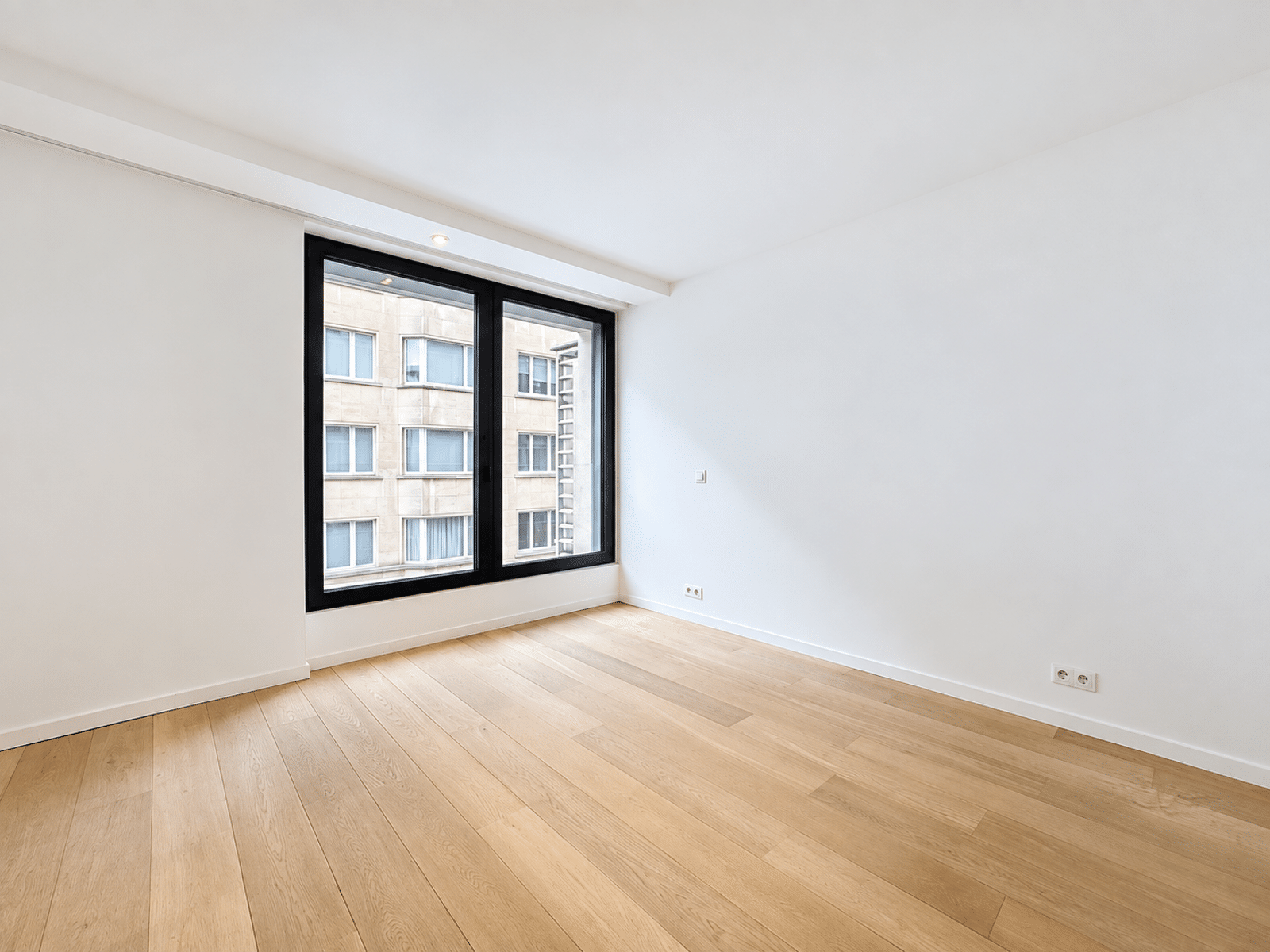 Pièce Lumineuse Avec Grande Fenêtre – You Real Estate Agency Pièce lumineuse d’appartement moderne avec parquet clair et grande fenêtre.