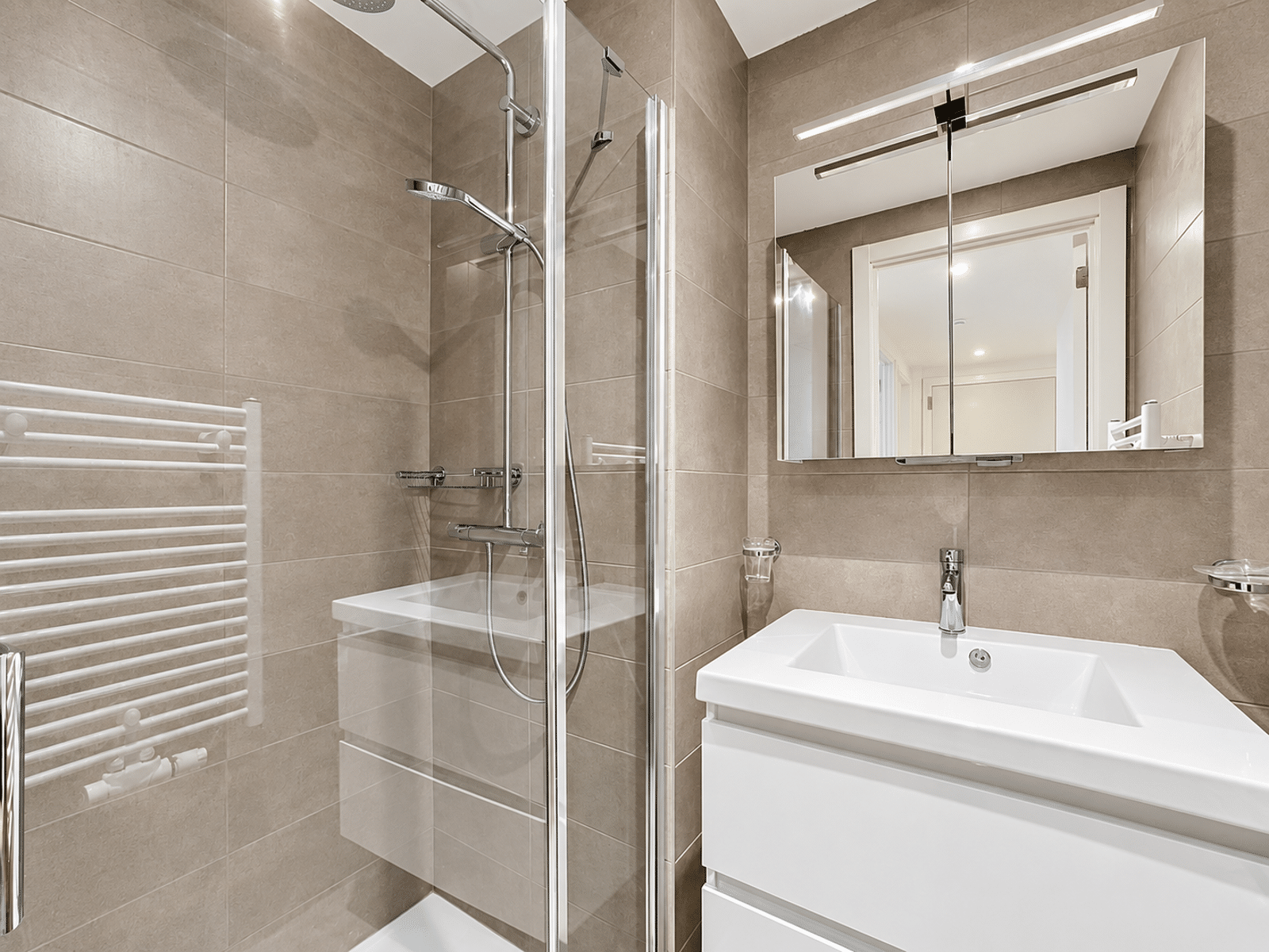Salle de Bain Moderne, Douche Vitrée – You Real Estate Agency Salle de bain moderne avec douche vitrée et meuble vasque dans appartement.