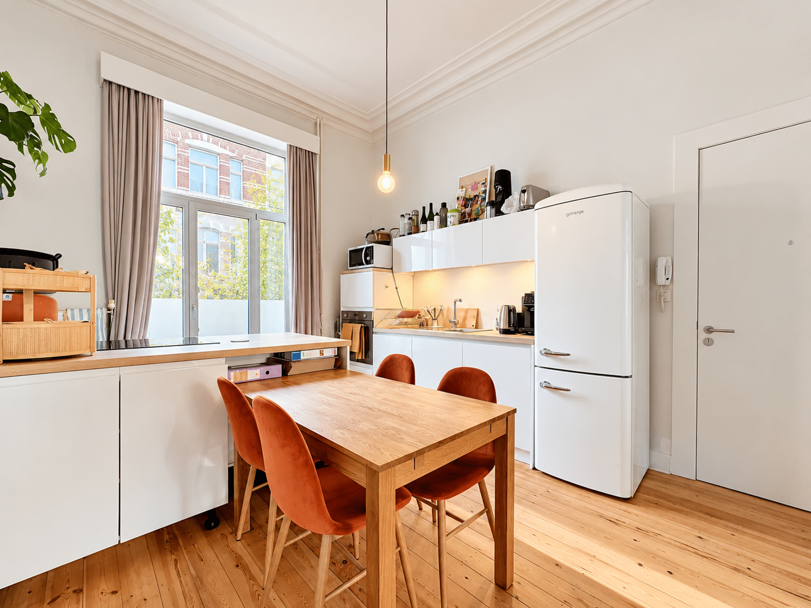 Open keuken met eetkamer – You Real Estate Agency Open keuken in een appartement met een lichte eetkamer en parketvloer.