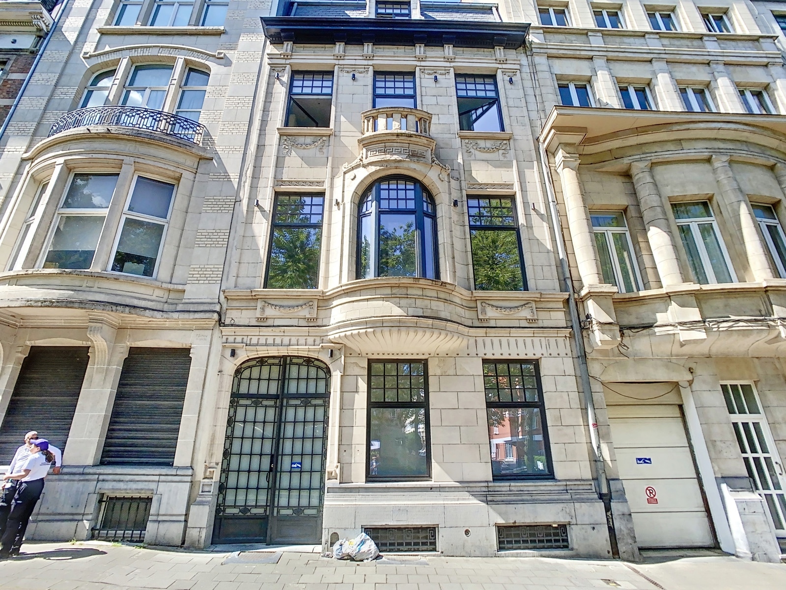 whise photo 9 Stone facade of a historic urban building with central arched window, small balcony, and decorative stonework.