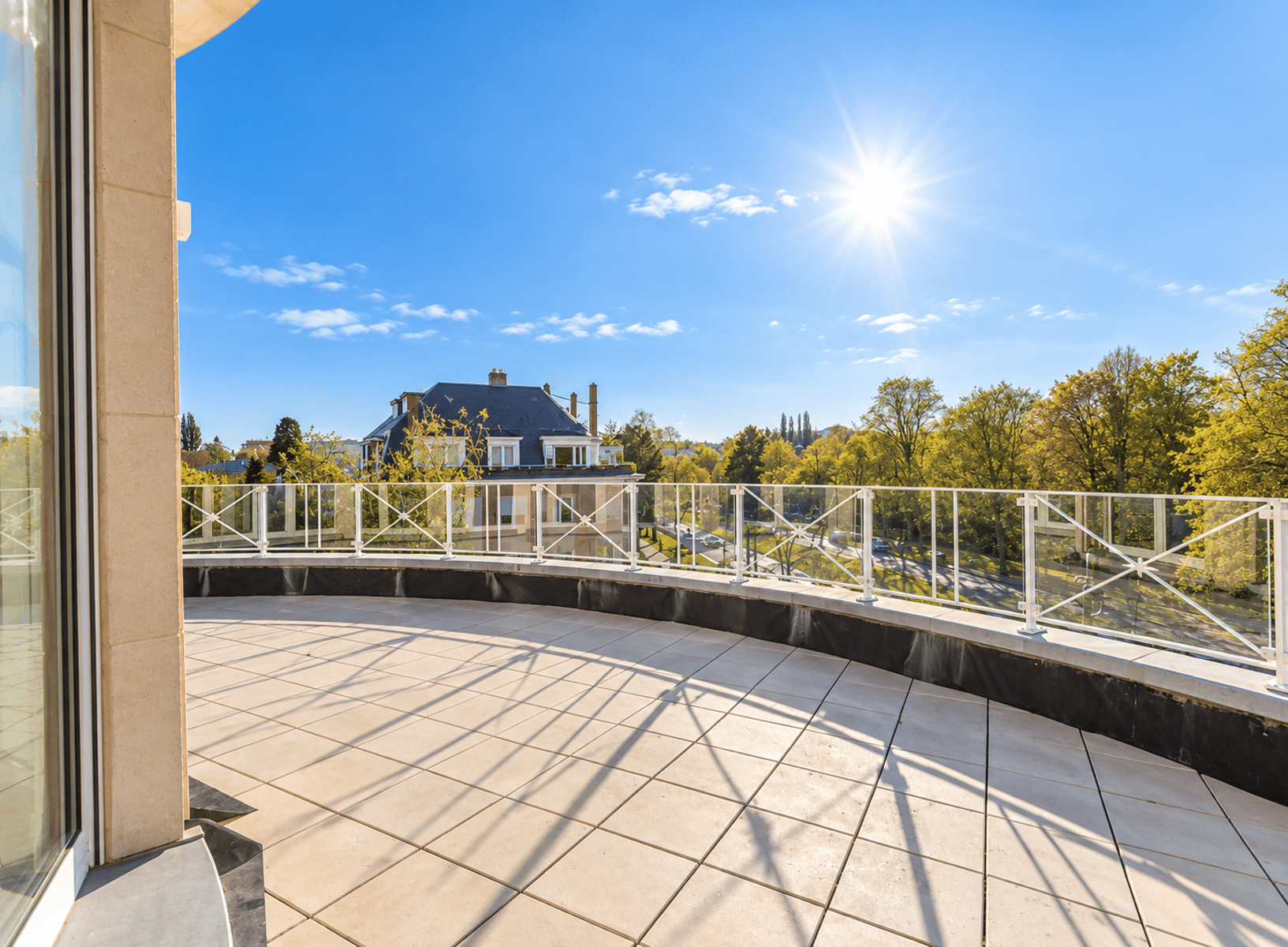 Terrasse Ensoleillée avec Vue Dégagée – You Real Estate Agency Terrasse spacieuse d’appartement avec vue dégagée et ensoleillée.