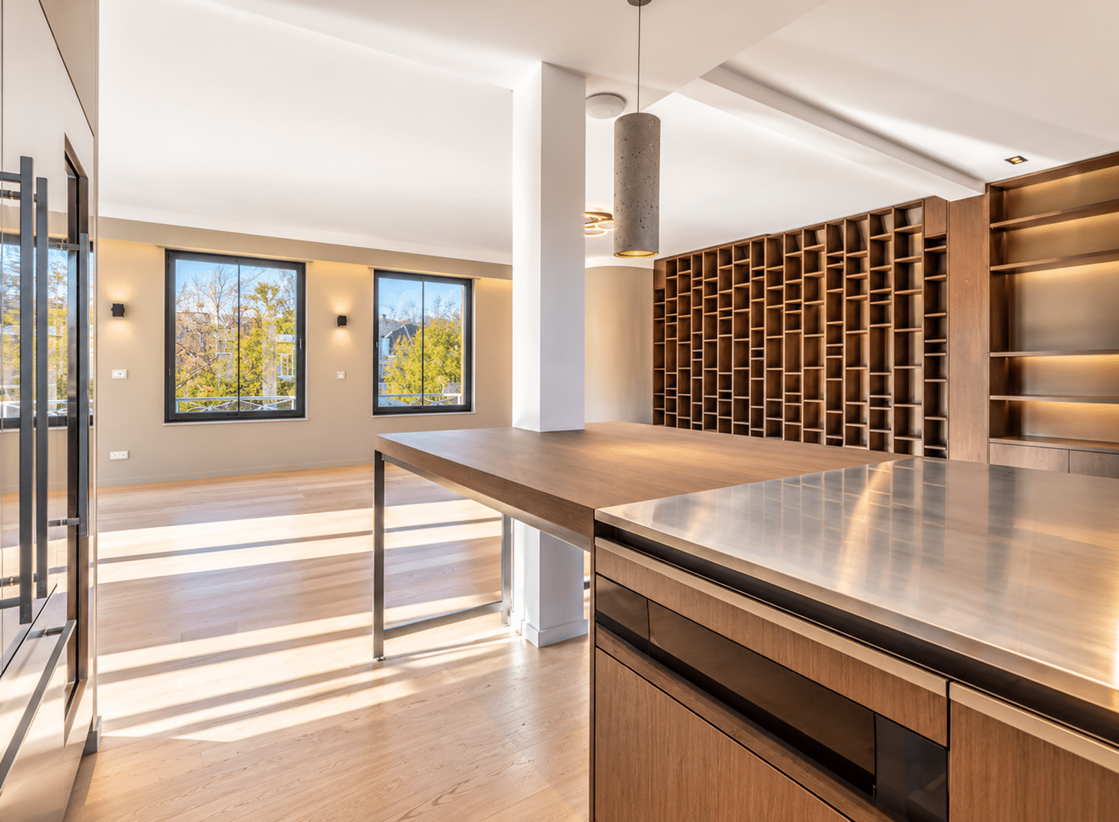 whise photo 6 Modern kitchen with a large wooden island, stainless steel counter, and a grid-style wine rack along the wall.”
