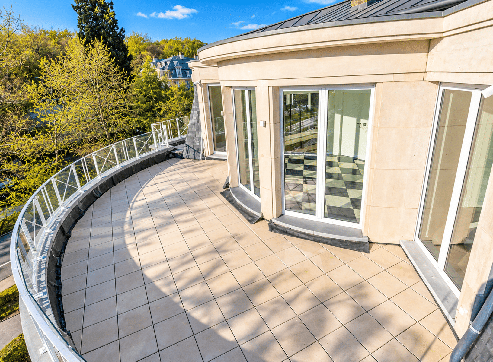 Terrasse Panoramique avec Vue Arborée – You Real Estate Agency Terrasse panoramique d’une maison contemporaine avec baies vitrées et vue arborée.