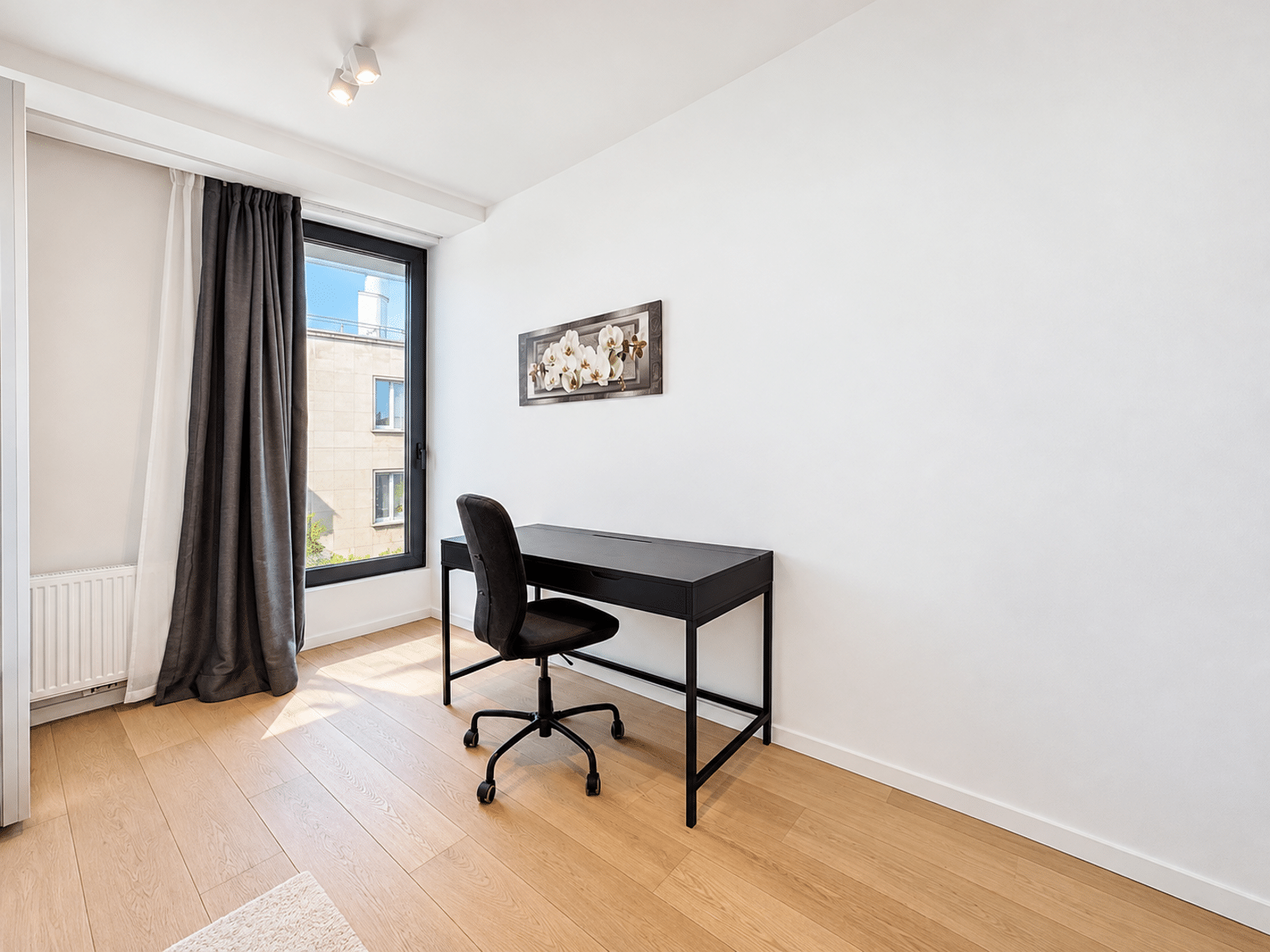 Bureau Lumineux Minimaliste – You Real Estate Agency Bureau lumineux dans appartement moderne avec parquet, grande fenêtre et décoration minimaliste.