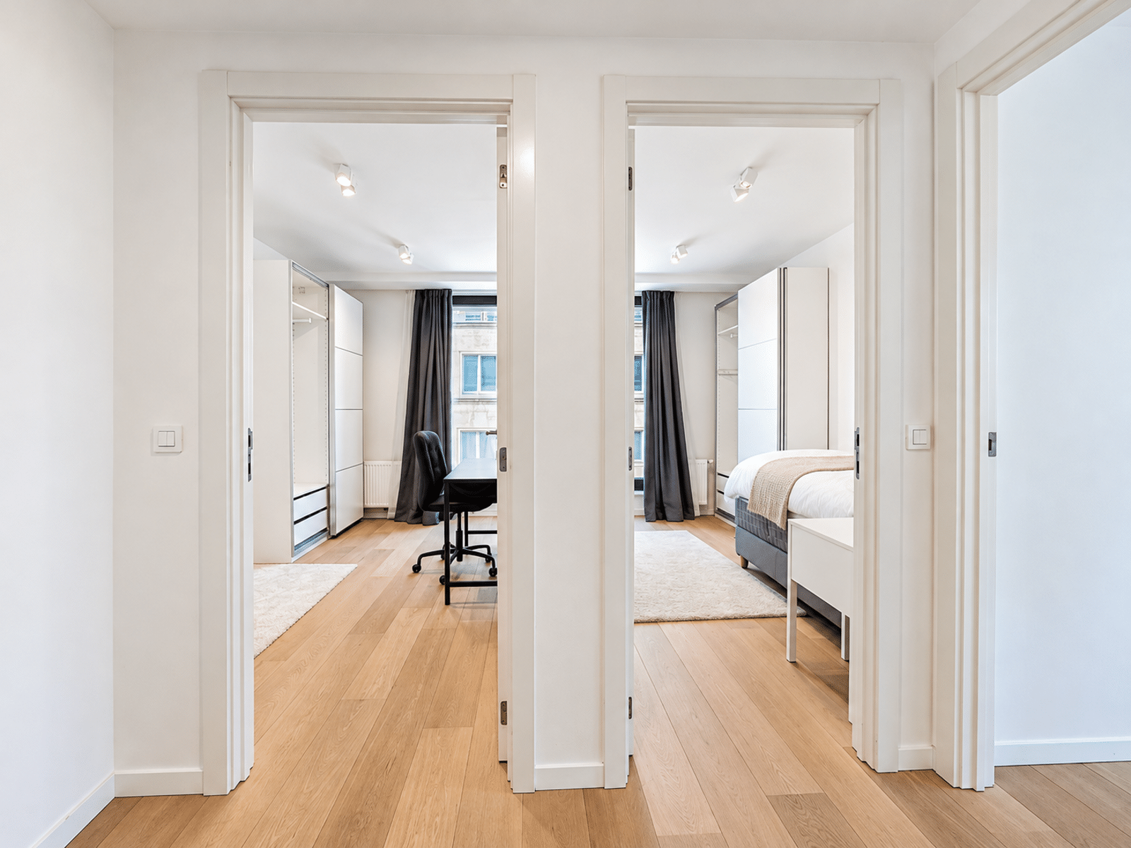 Couloir Lumineux d’Appartement Moderne – You Real Estate Agency Couloir lumineux d’appartement moderne avec chambres, parquet clair et rangements intégrés.