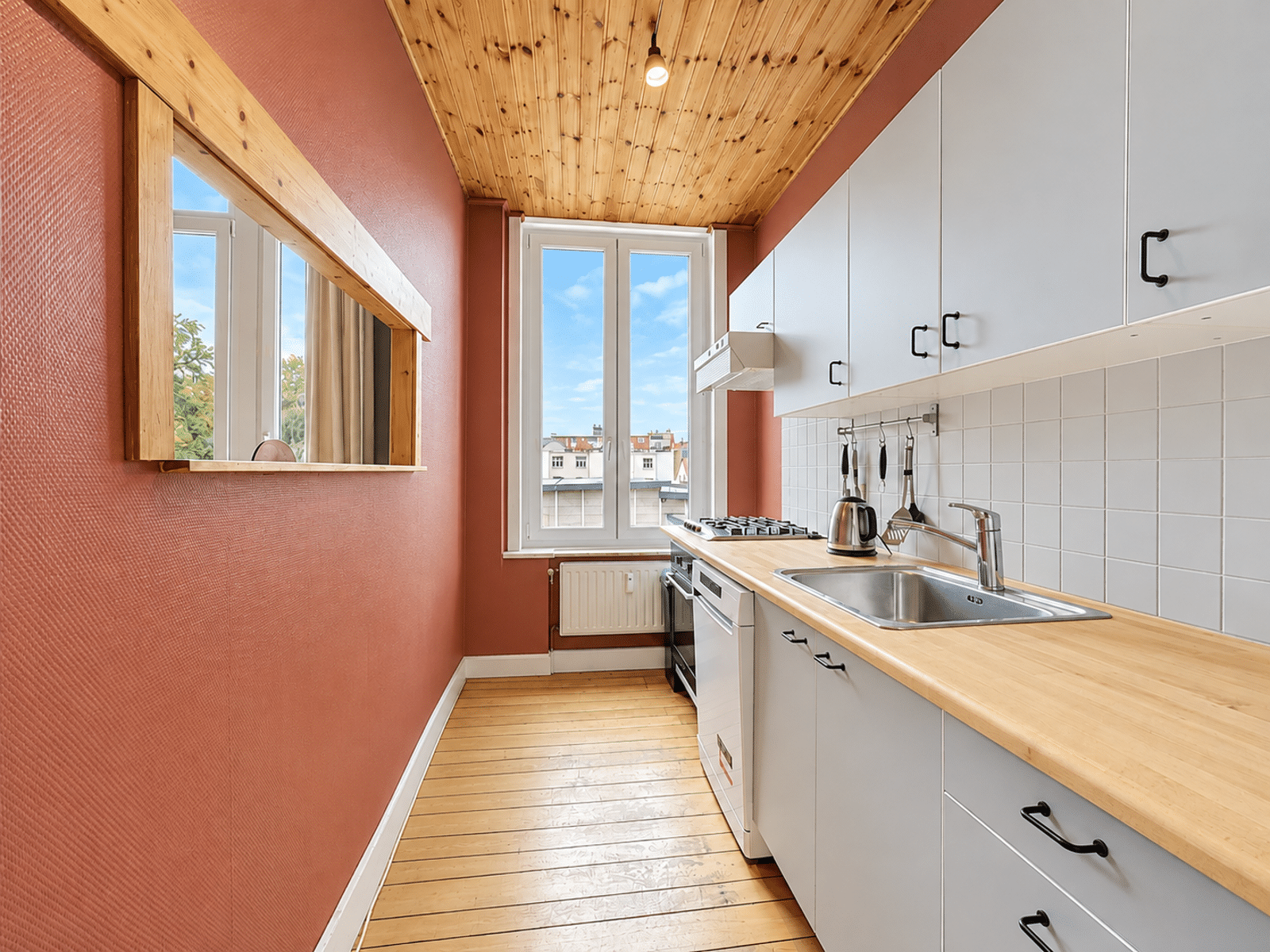 Cuisine Équipée Lumineuse – You Real Estate Agency Cuisine équipée lumineuse d’un appartement, parquet bois et meubles gris.
