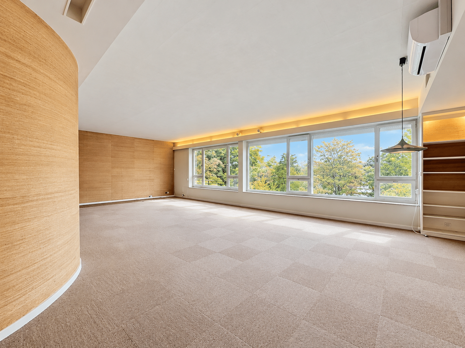 Salon Lumineux avec Grandes Fenêtres – You Real Estate Agency Salon lumineux avec grandes fenêtres, boiseries et moquette dans appartement moderne.