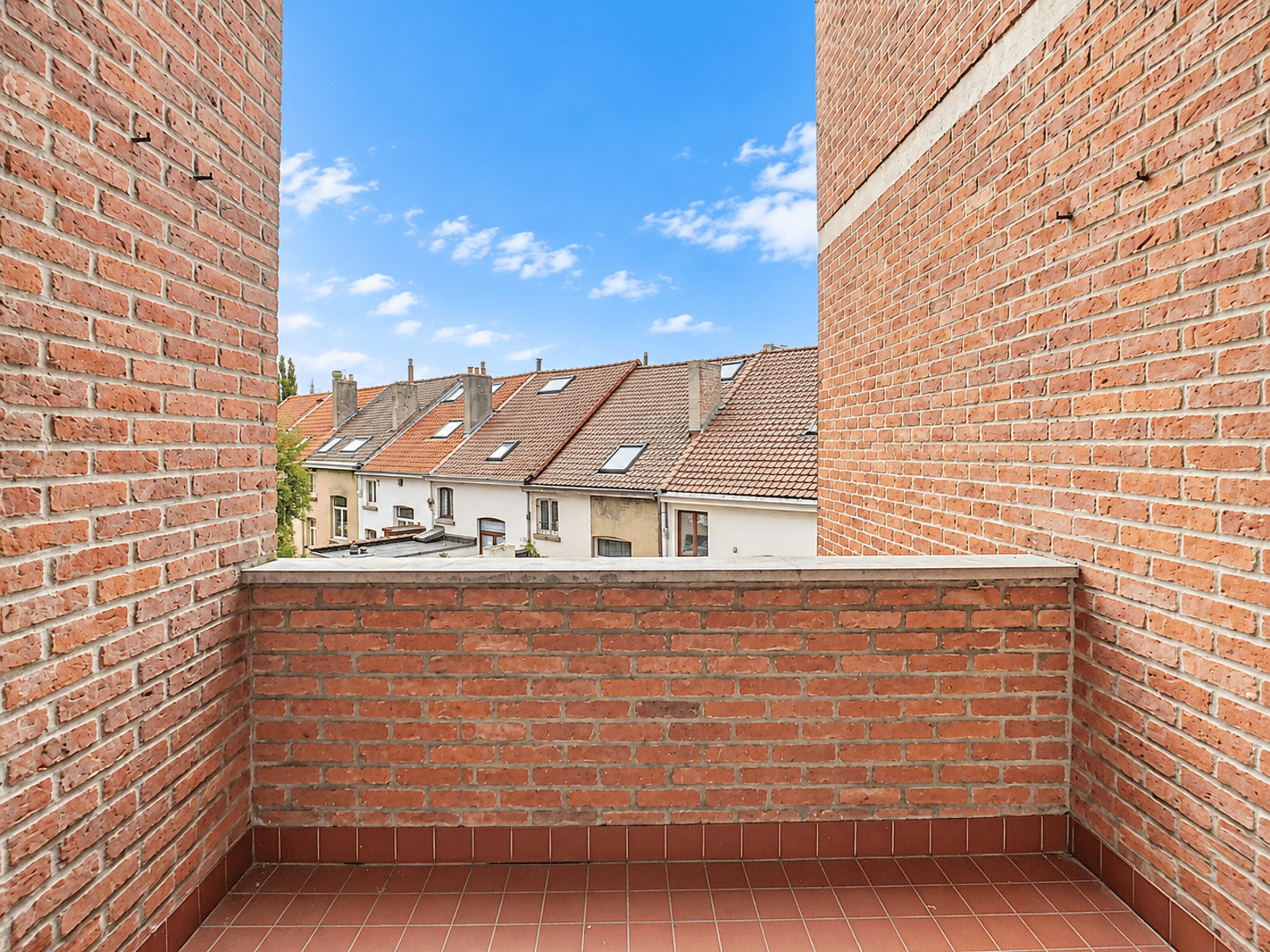 Terrasse En Brique Avec Vue Sur Toits – You Real Estate Agency Terrasse en brique d’appartement avec vue sur toits résidentiels.