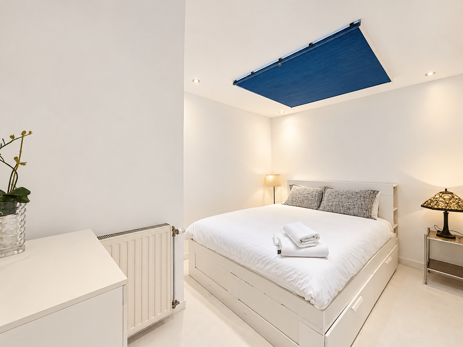 Chambre Moderne avec Lit Double – You Real Estate Agency Chambre moderne et lumineuse avec lit double et rangements dans appartement minimaliste.