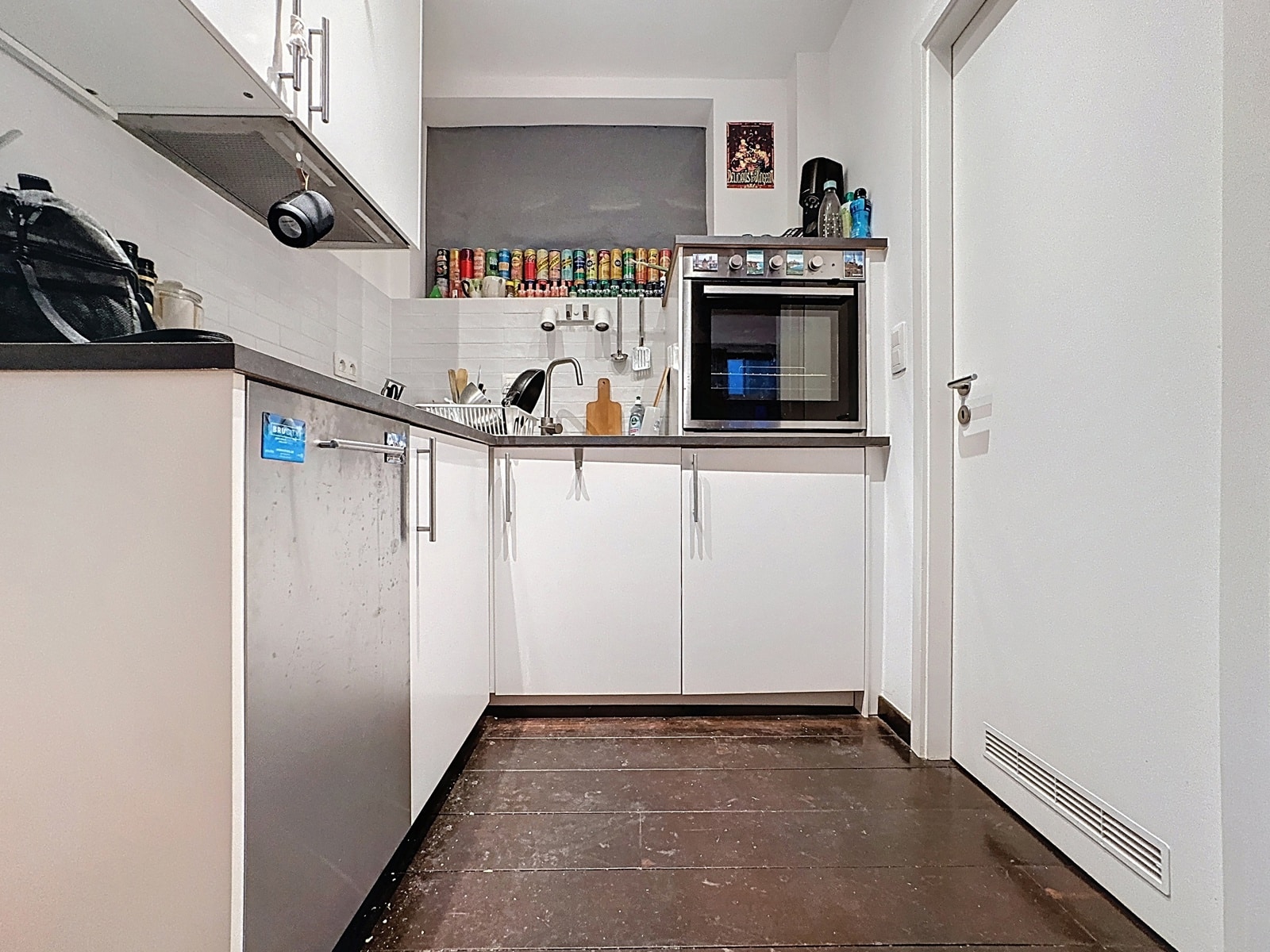 Cuisine Blanche Équipée – You Real Estate Agency Cuisine équipée moderne blanche dans un appartement, avec électroménager inox et rangements.